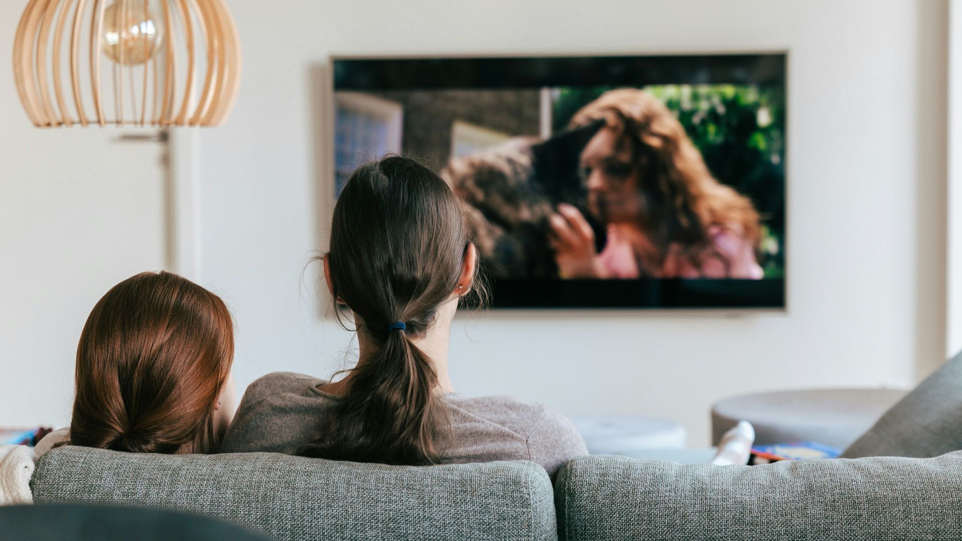 a couple of women sitting on top of a couch