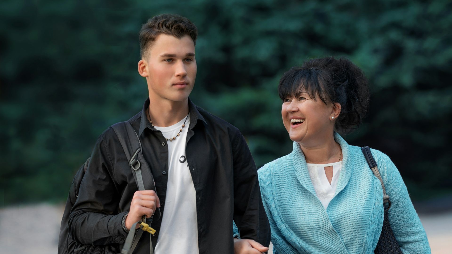 man in blue v neck shirt and black jacket standing beside woman in blue v neck
