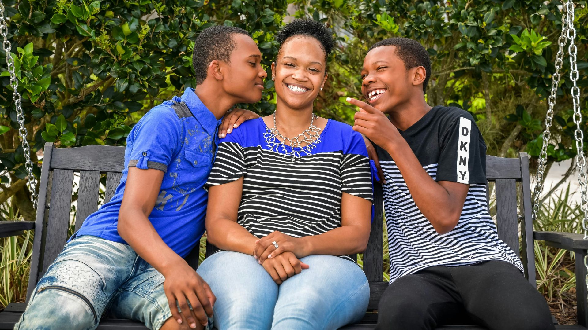 a couple of kids sitting on top of a swing