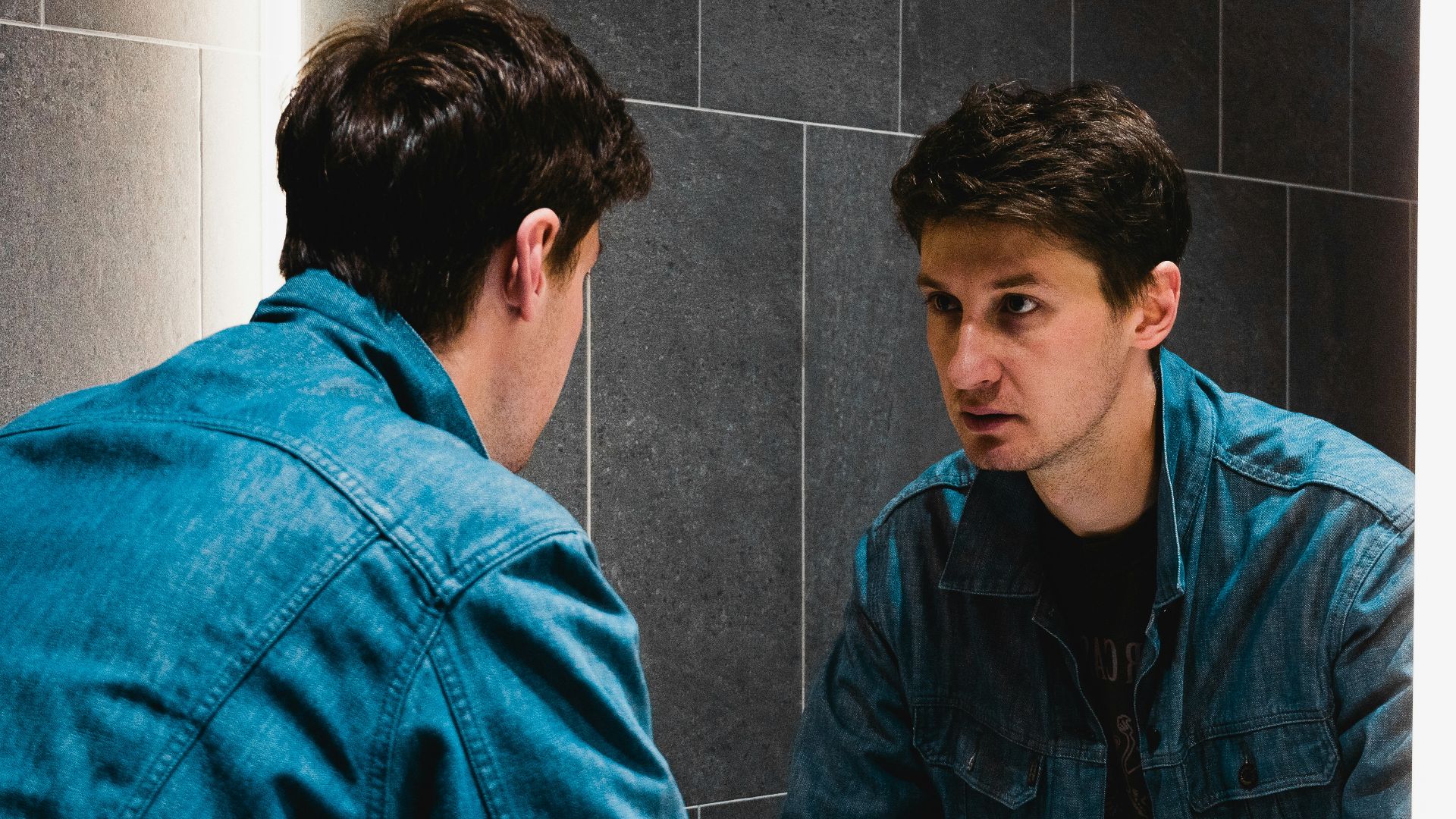 A man looking at himself in the mirror