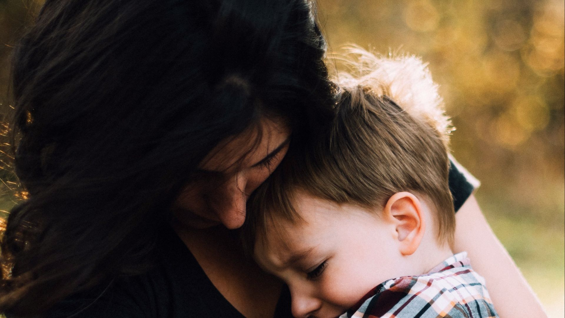 woman hugging boy on her lap