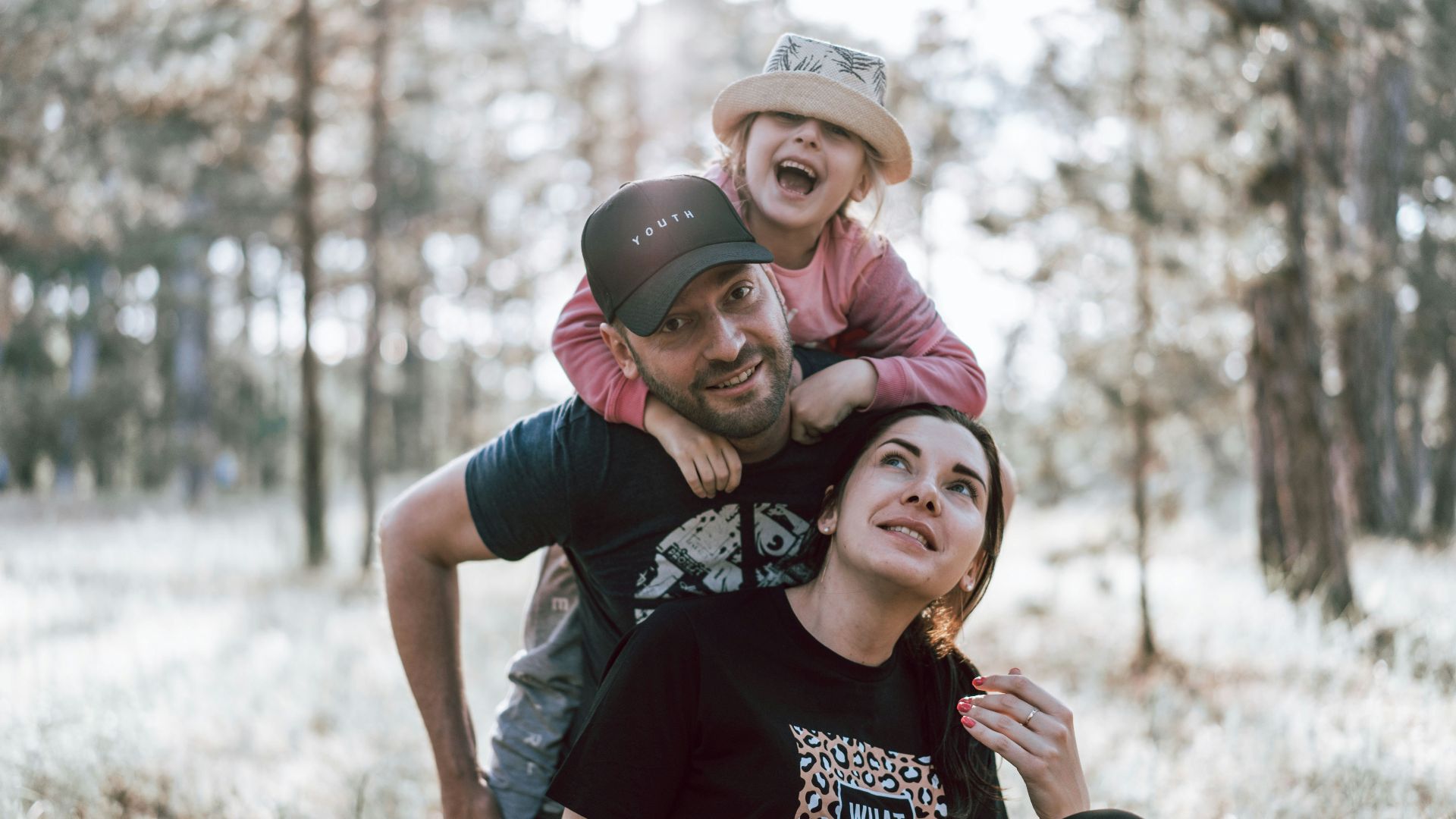 a man holding a little girl on his shoulders