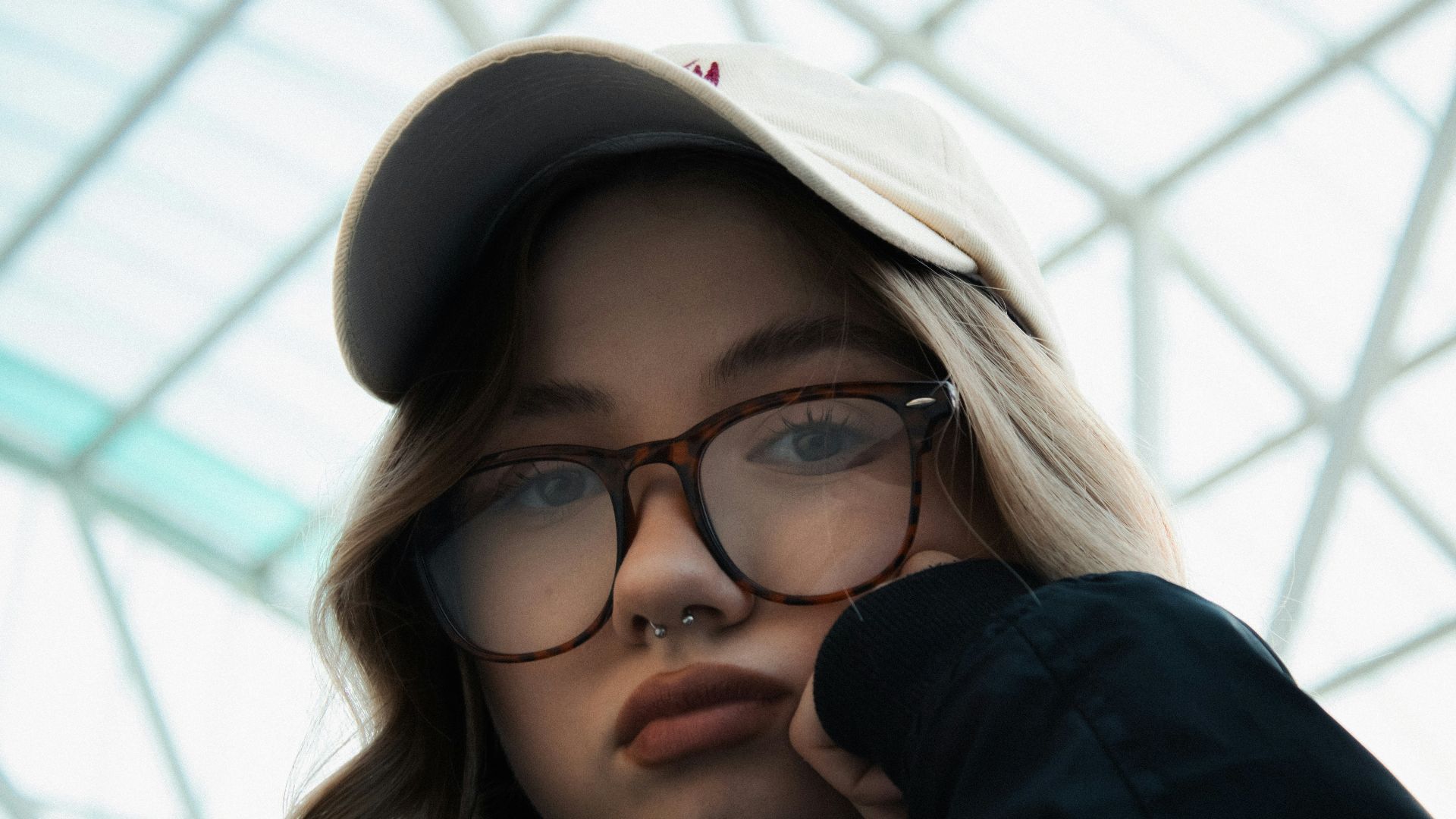 Young woman wearing glasses and a hat.