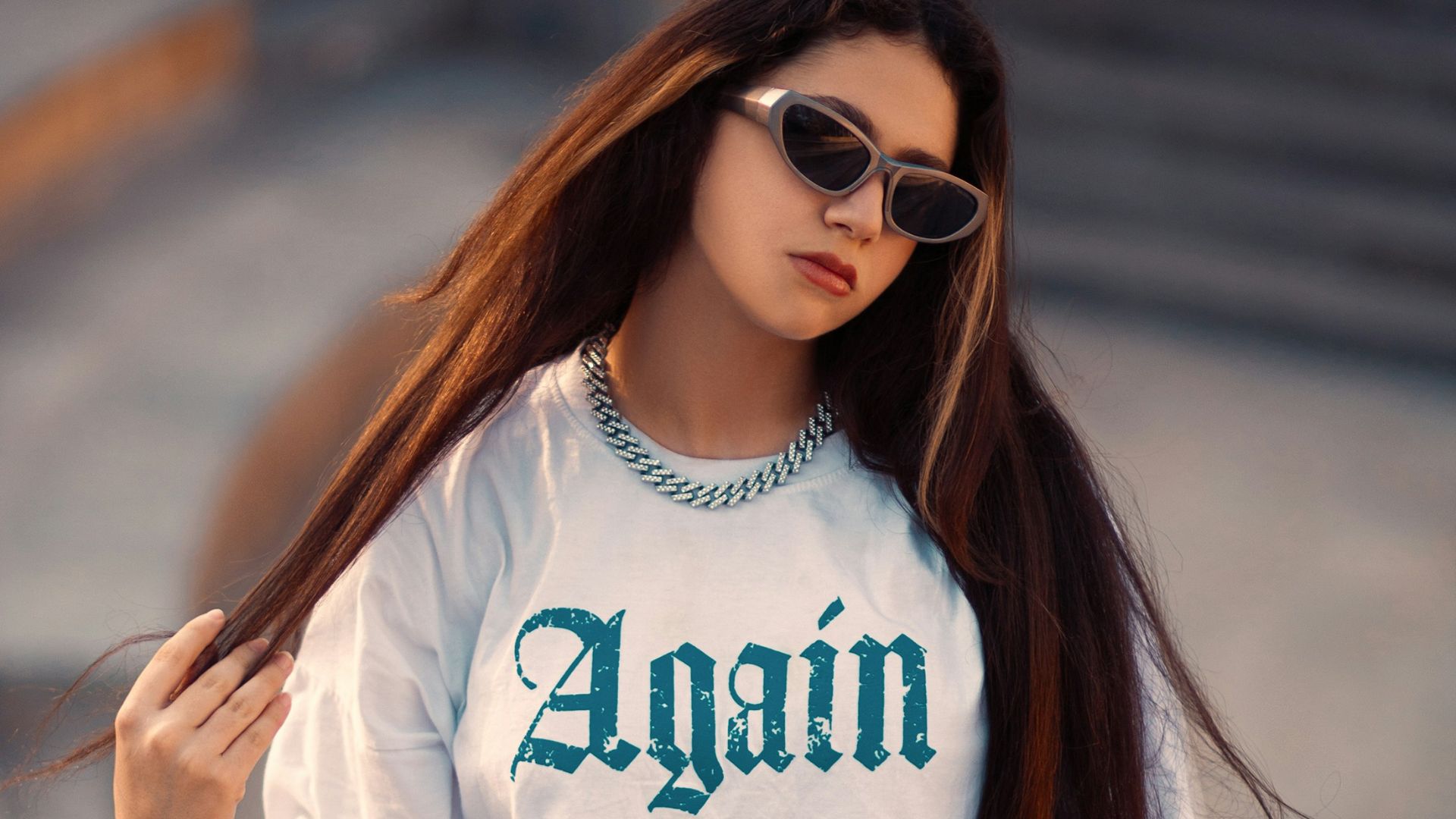 a woman with long hair wearing sunglasses and a t - shirt