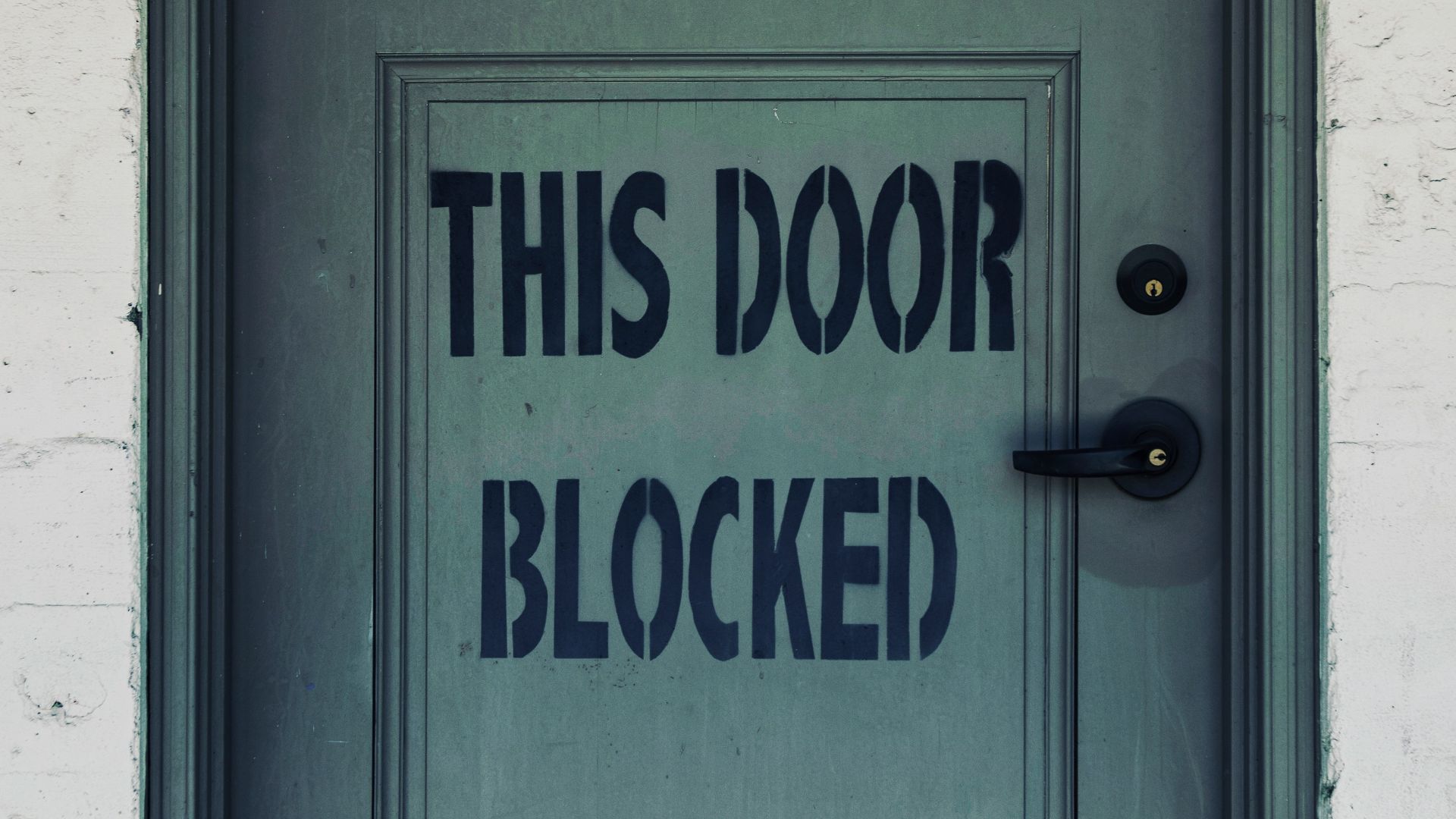 blue wooden door with white concrete wall