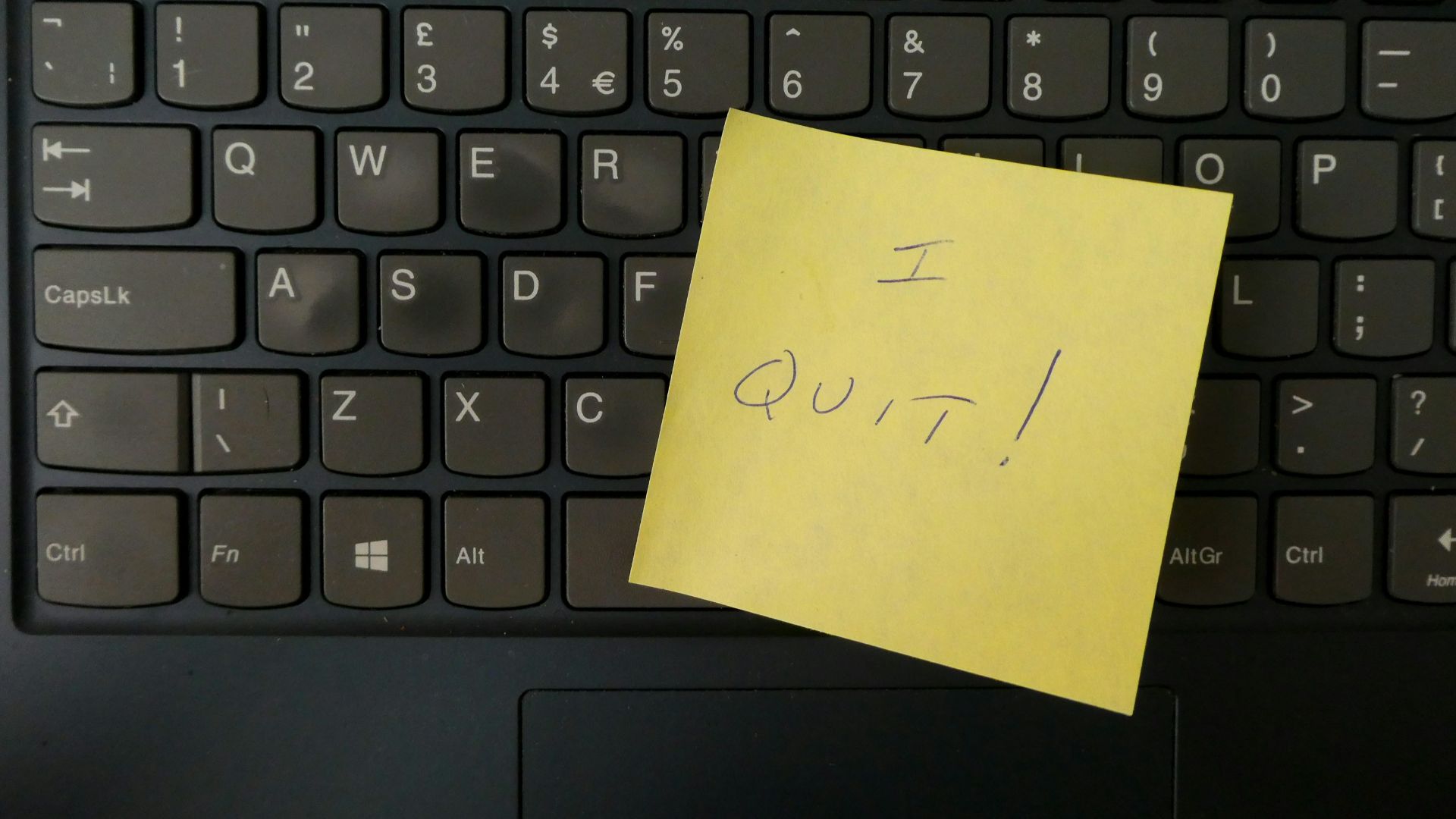 a yellow notepad on a keyboard