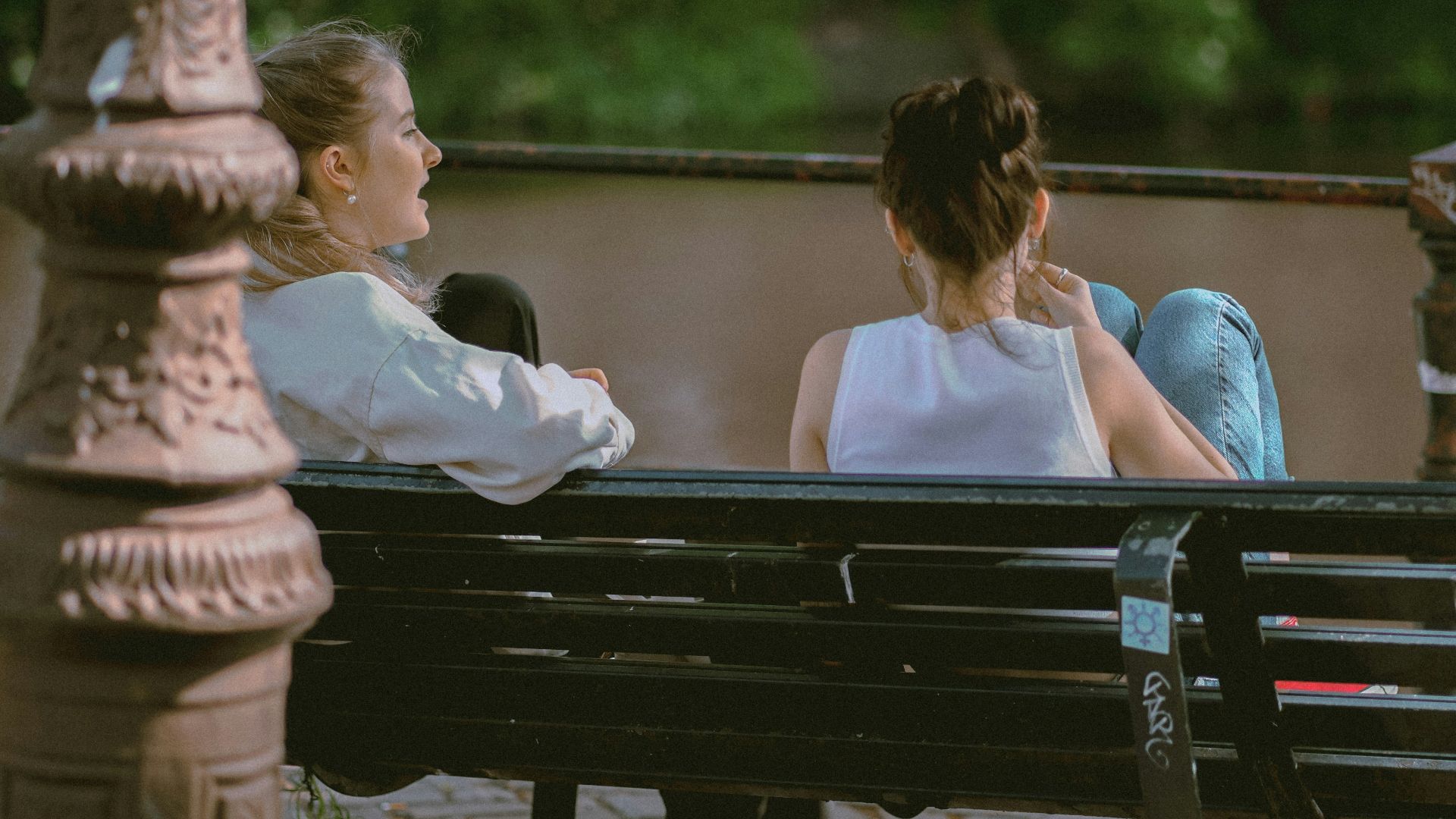 two women sitting on a bench
