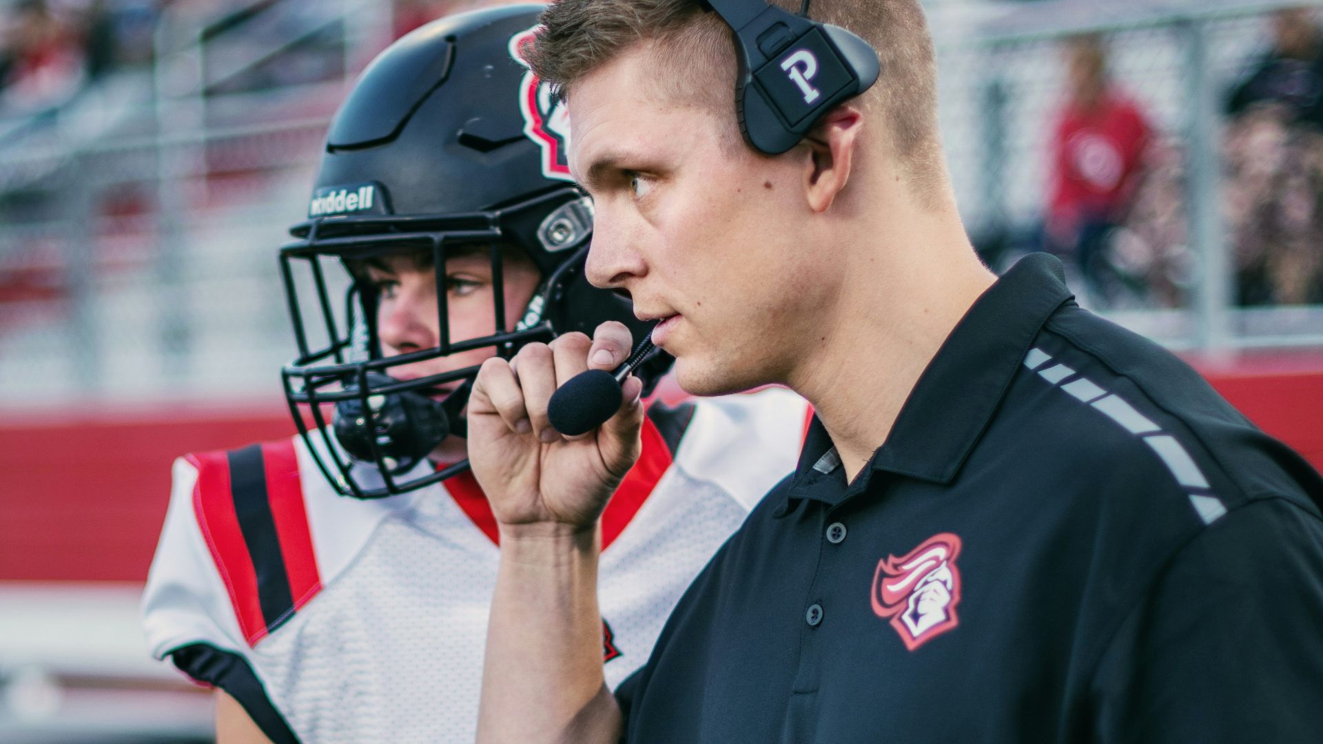 a football player talking to a referee on the sidelines