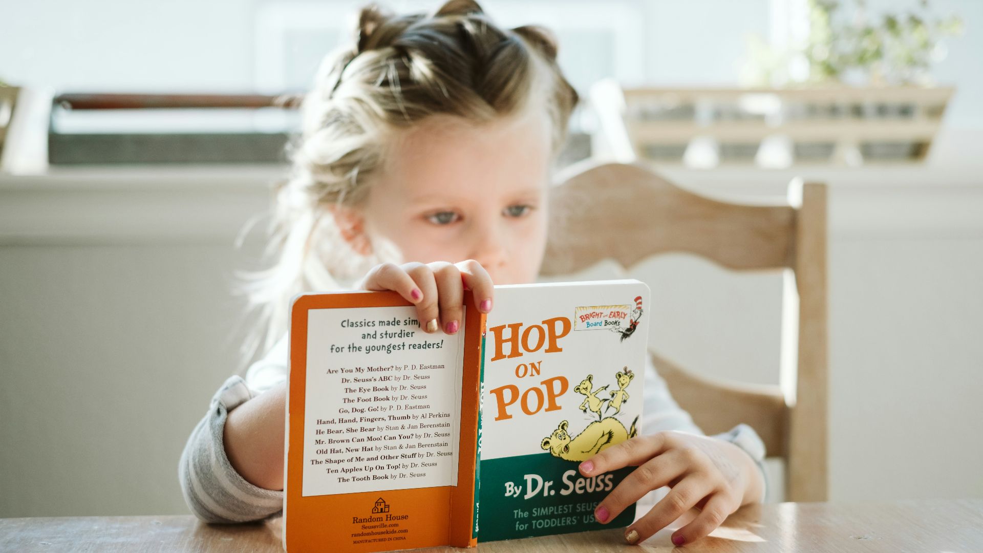 girl sitting while reading book