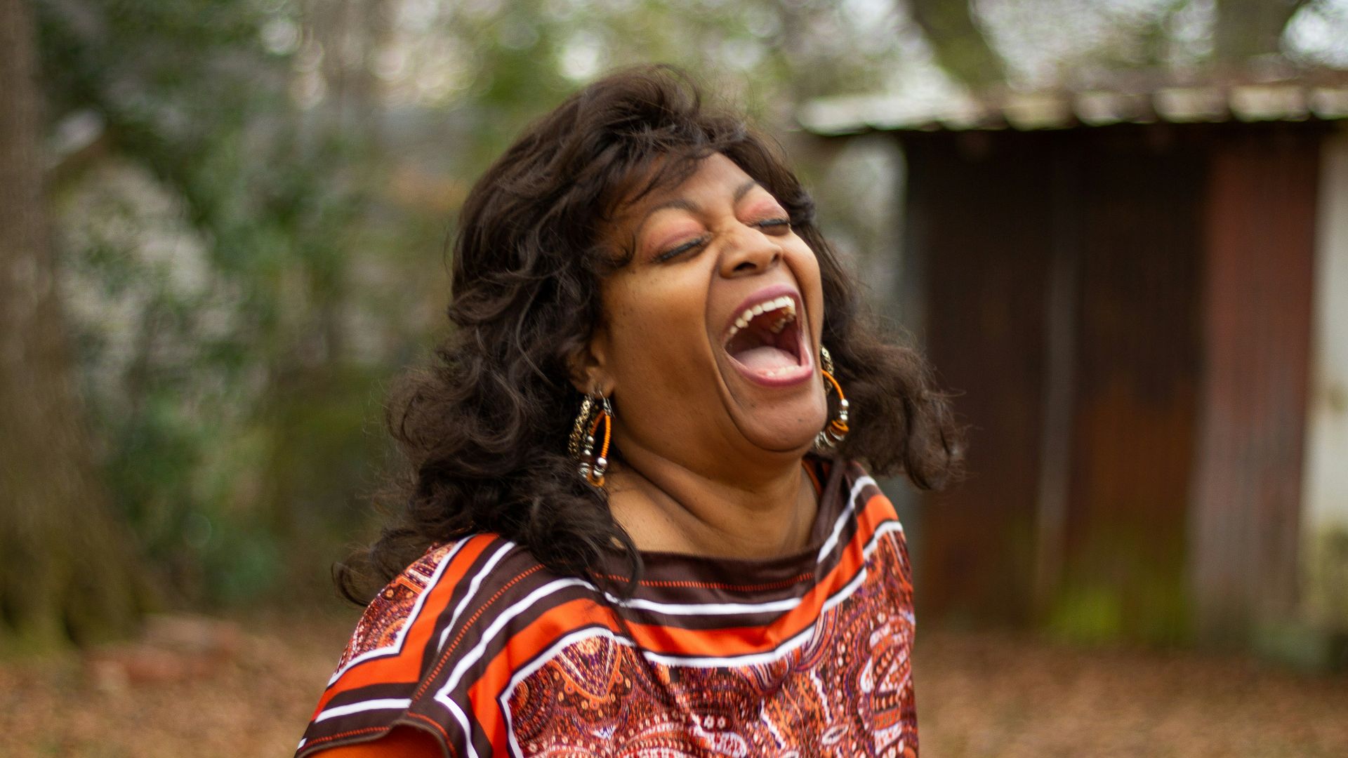 woman in orange and black dress smiling