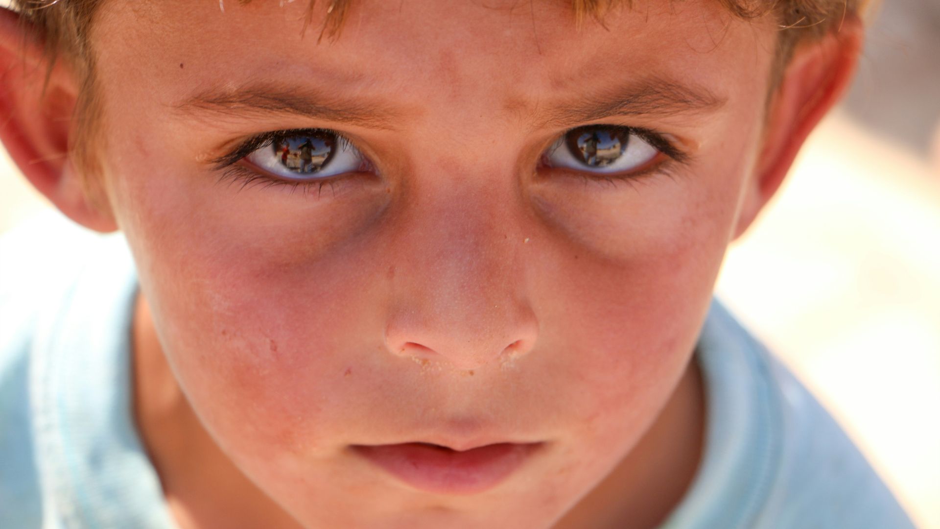 A close up of a young boy with blue eyes