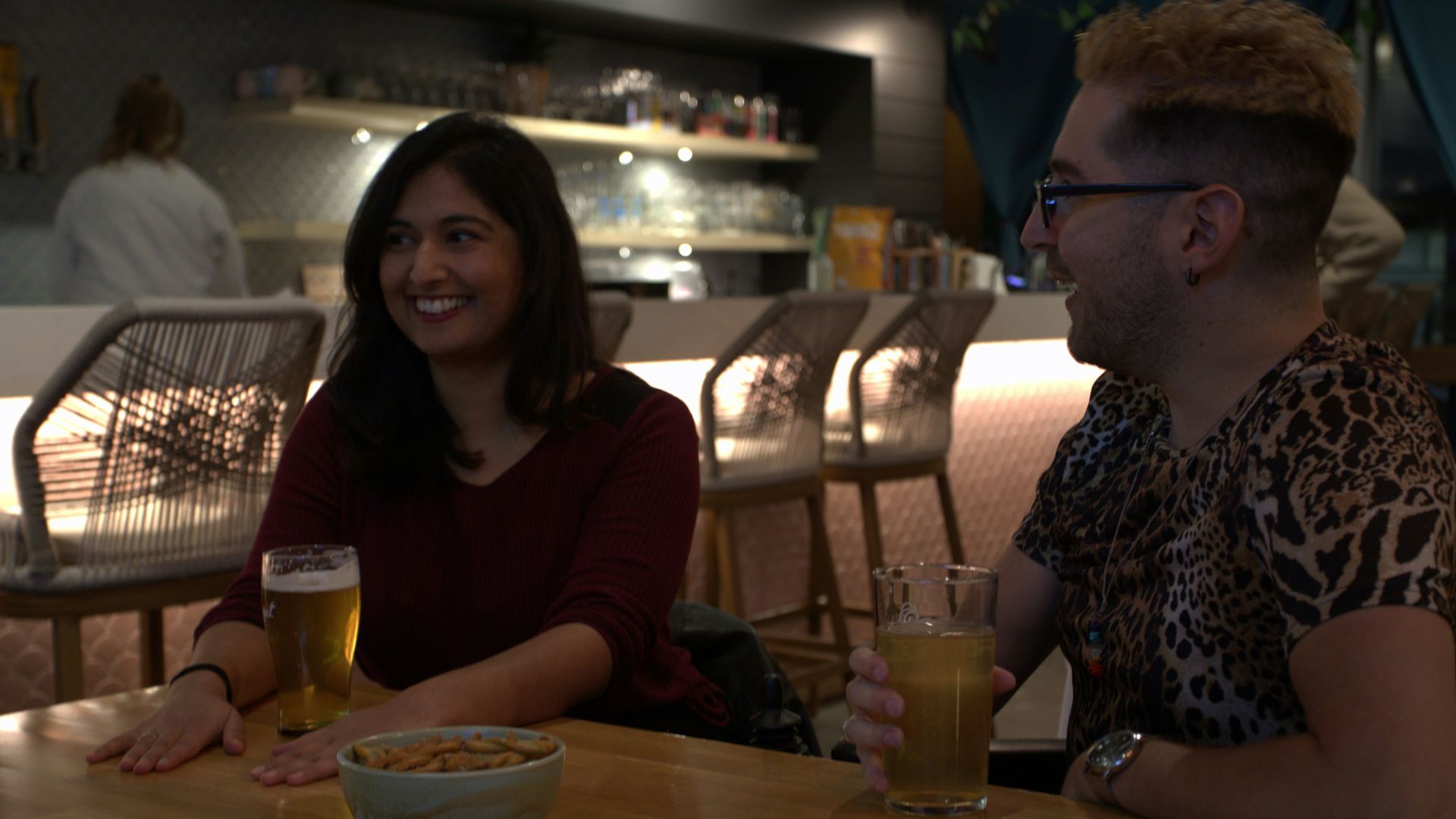 a man and a woman sitting at a table with drinks