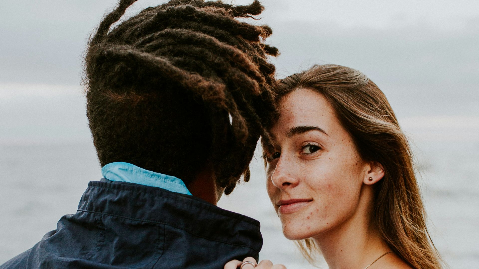 woman in blue long sleeve shirt beside woman in gray long sleeve shirt