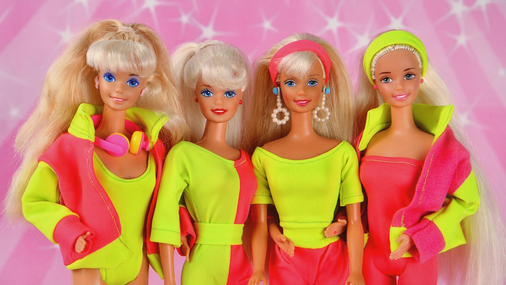 Four 80s barbie dolls posing together.