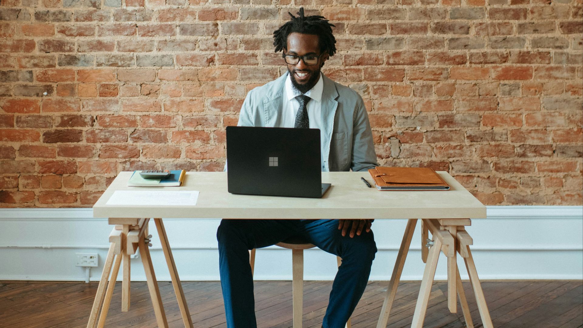 a man sitting at a table with a laptop on it