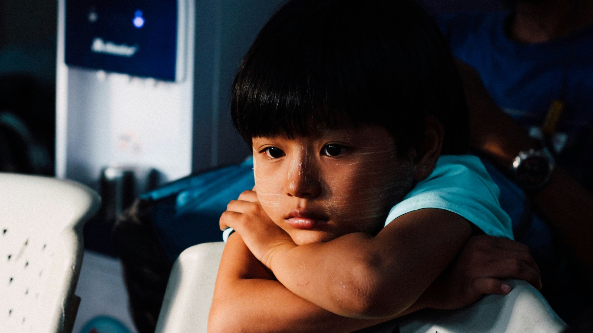 boy leaning on white chair