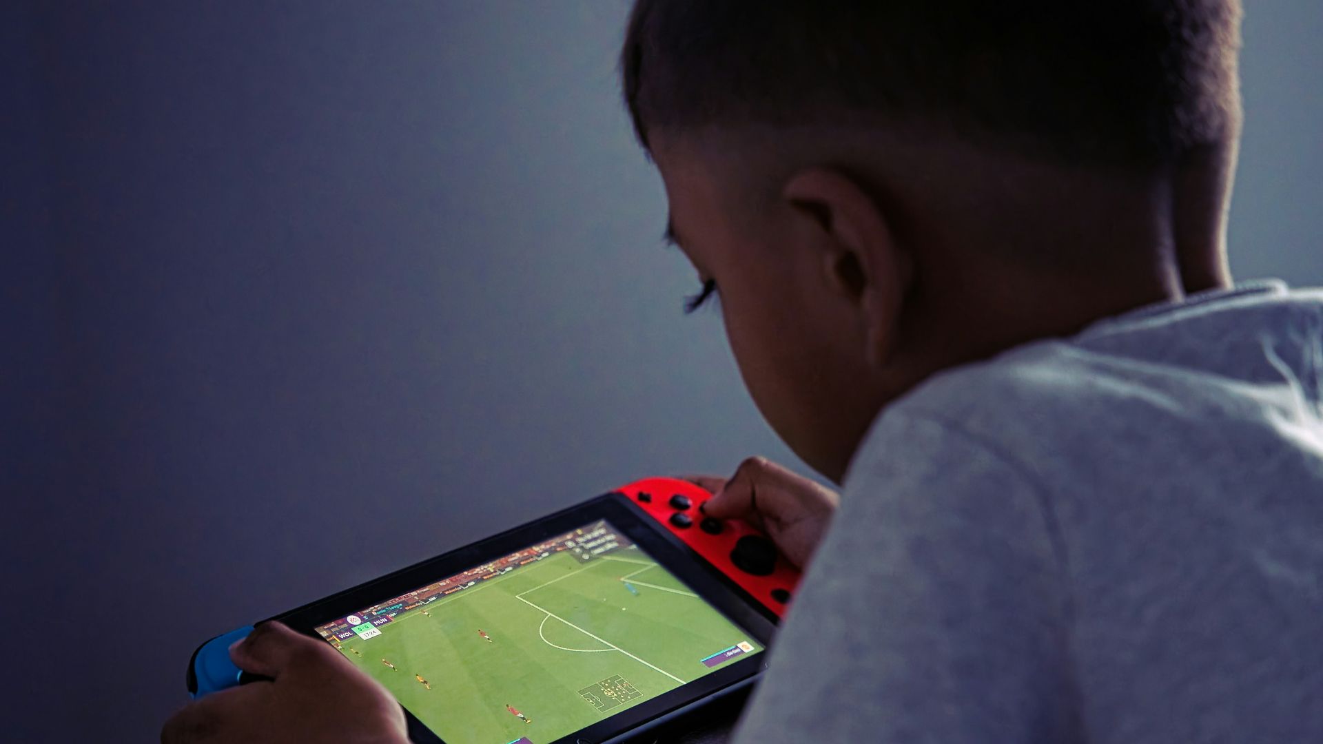a young boy playing a video game on a tablet