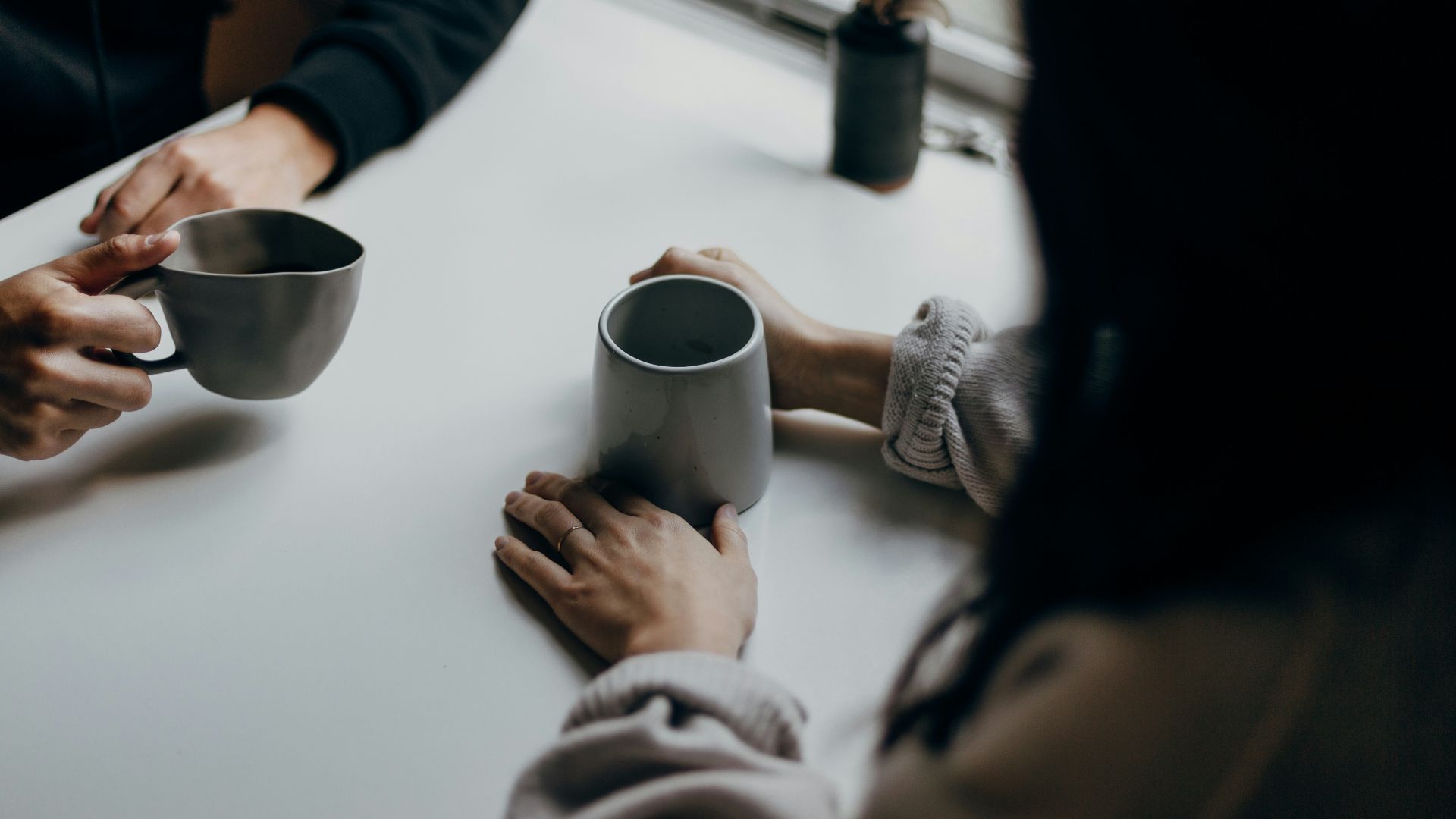 woman in black long sleeve shirt holding black ceramic mug