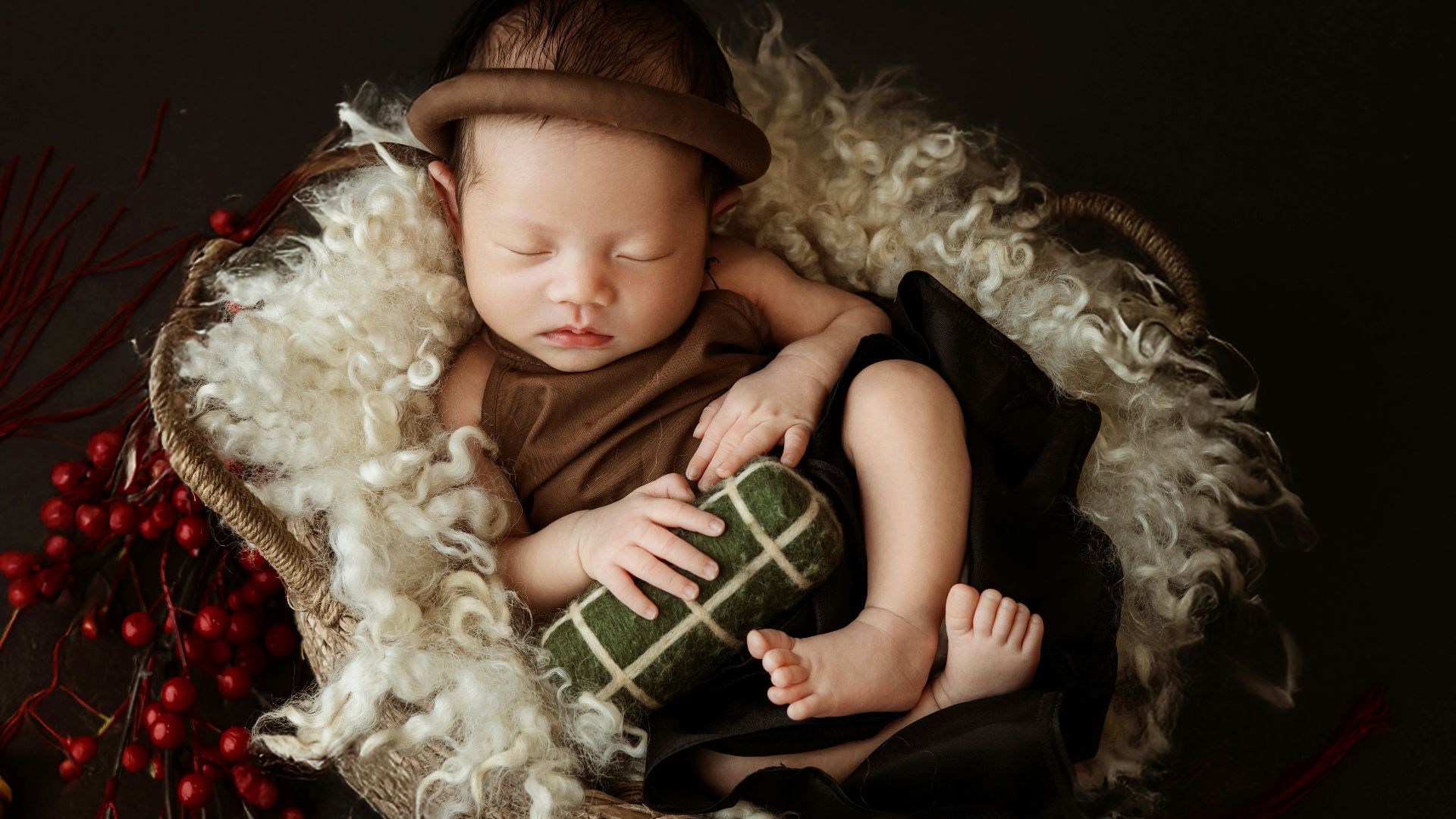 A baby sleeping in a basket with a christmas decoration