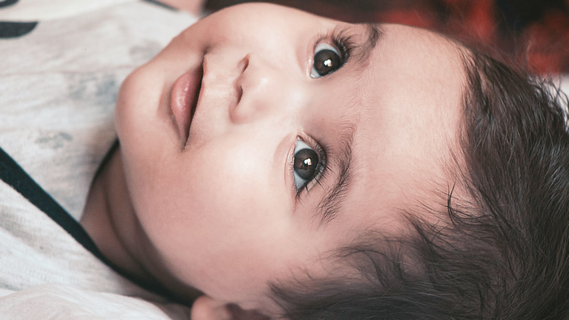 girl lying on white textile