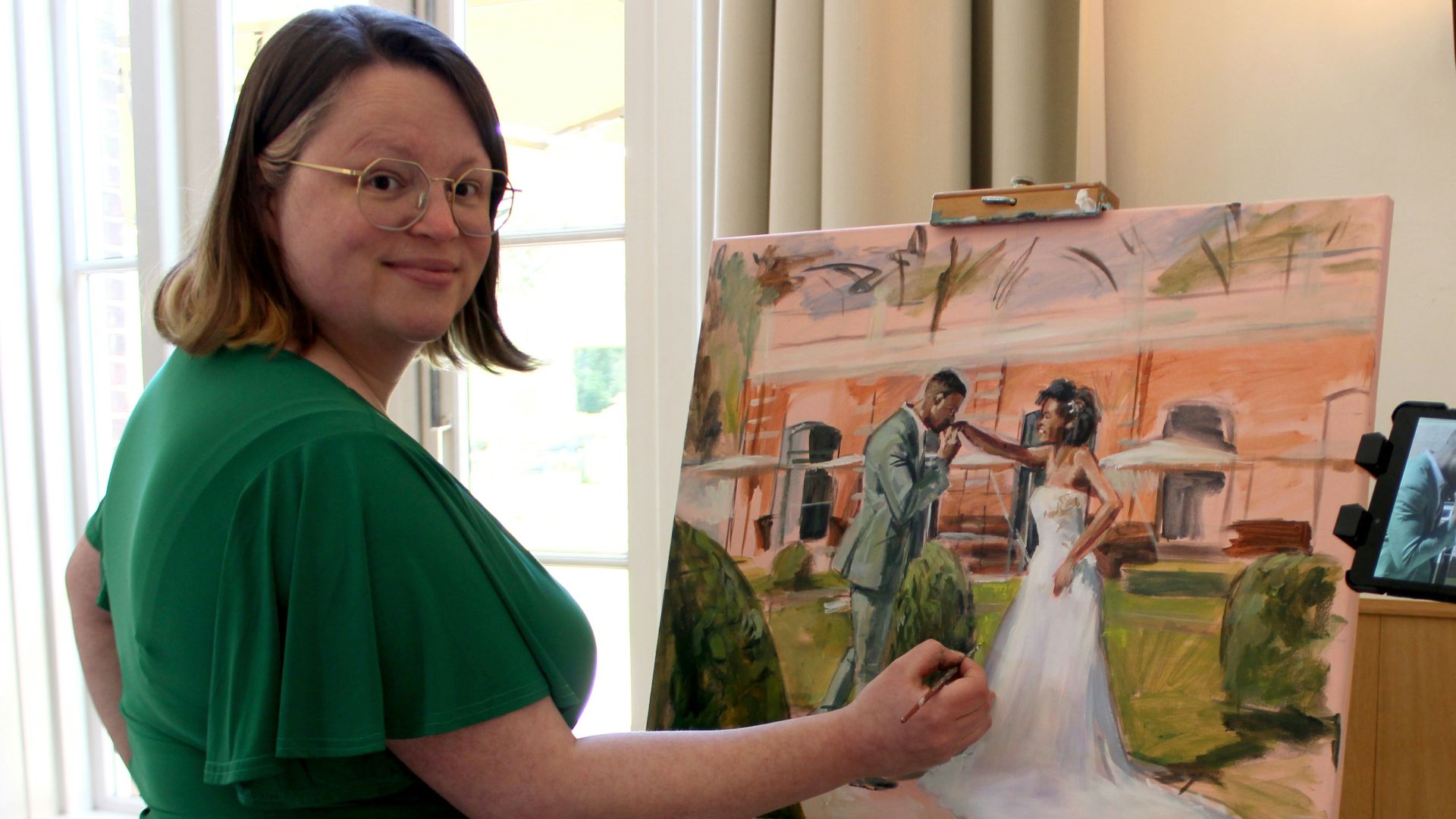 Artist paints a portrait of a wedding couple.