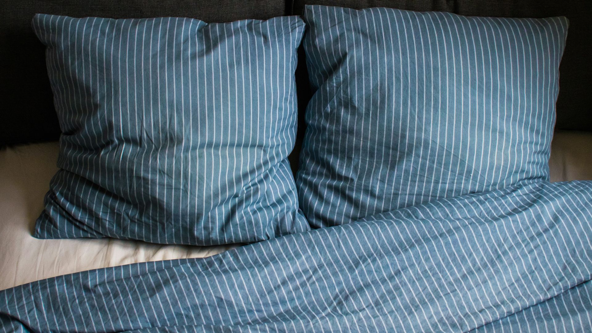 a bed with two pillows and a blanket on top of it