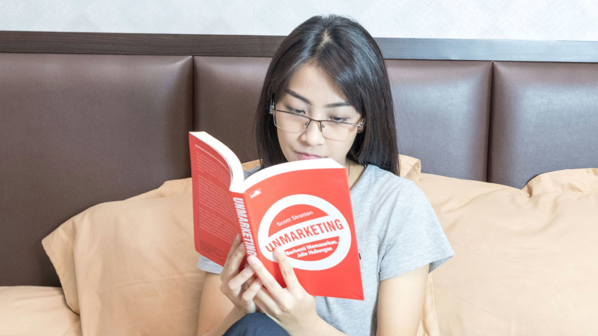 woman in gray crew neck t-shirt holding red and white box