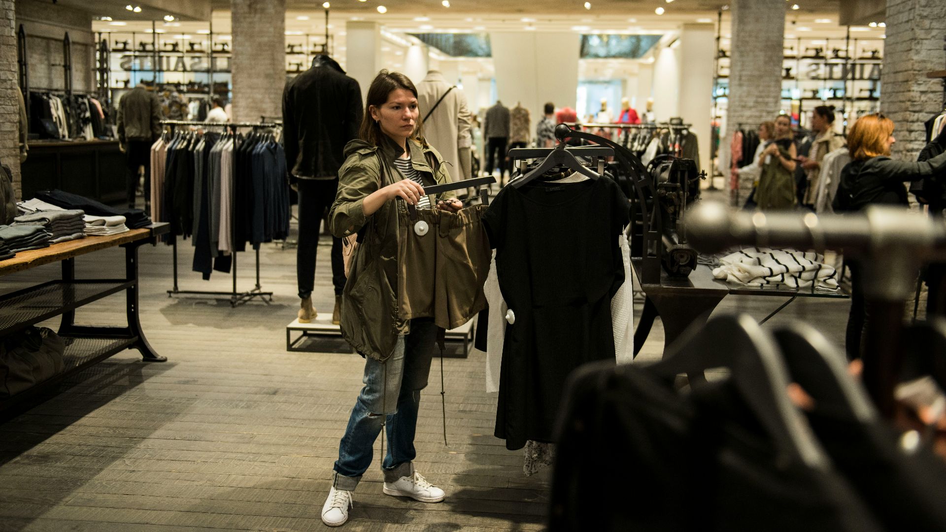 woman holding apparel inside shopping building