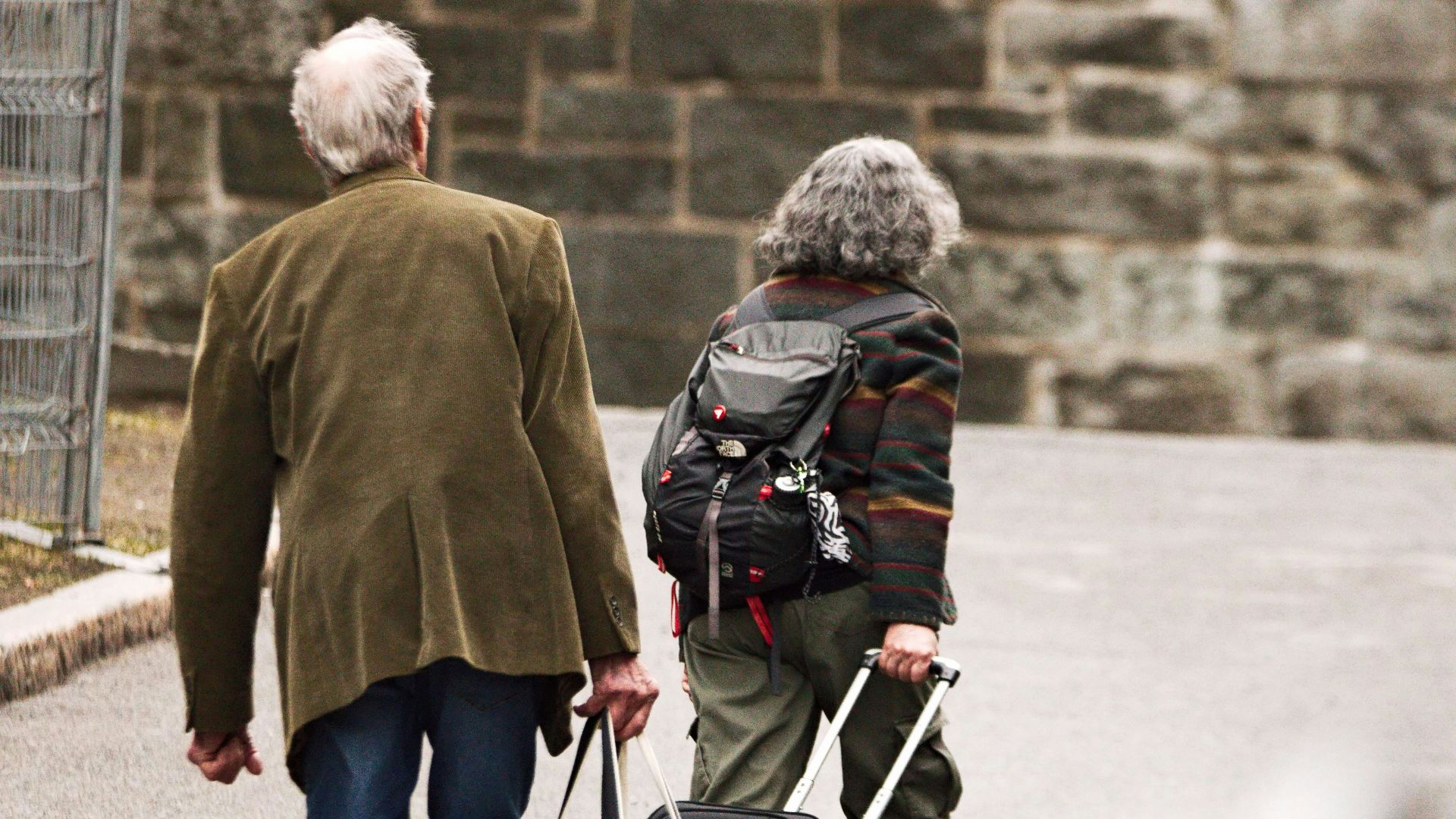 a man and a woman walking down the street with luggage