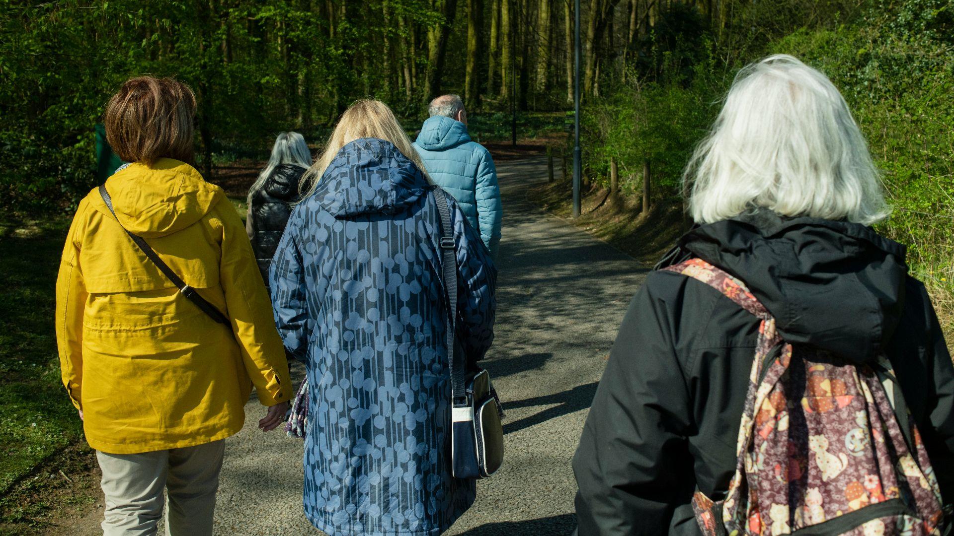 a group of people walking down a dirt road