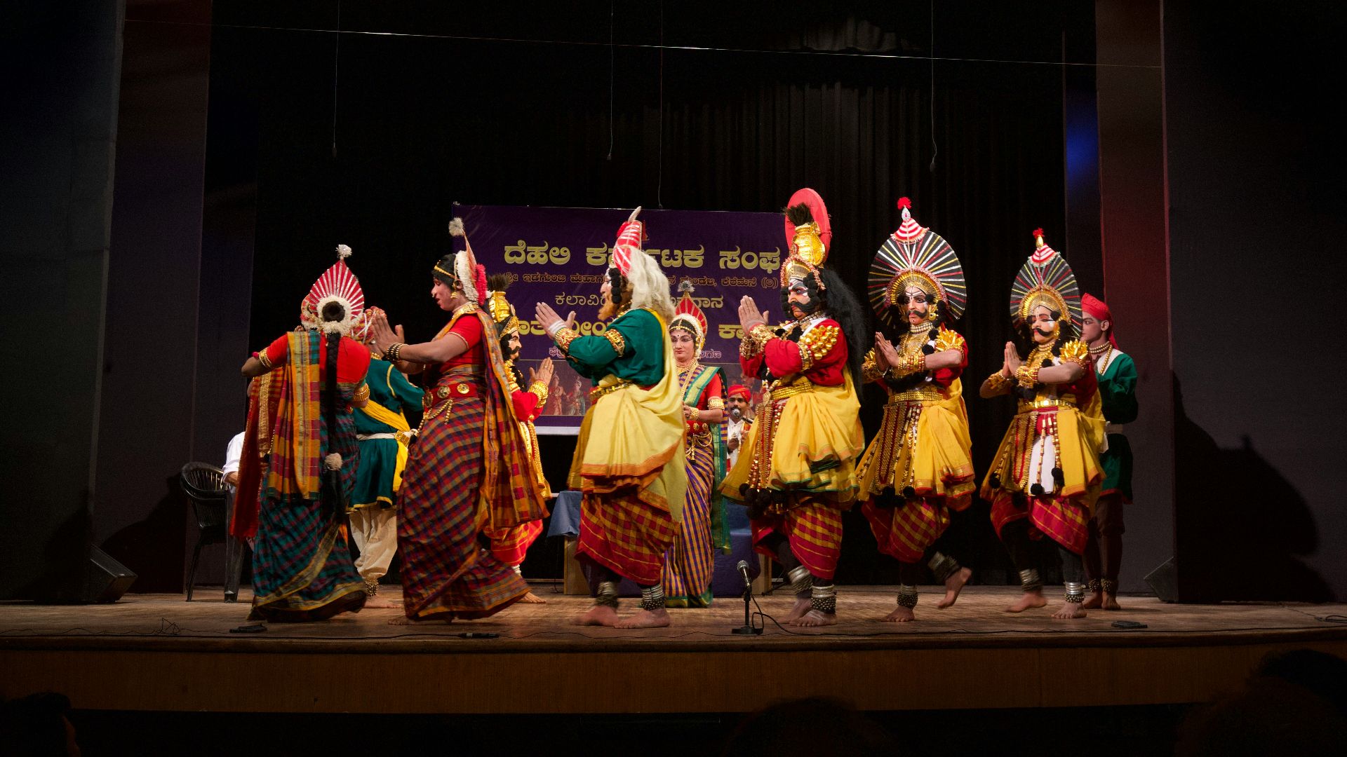 group of people in gold and red traditional dress dancing on stage