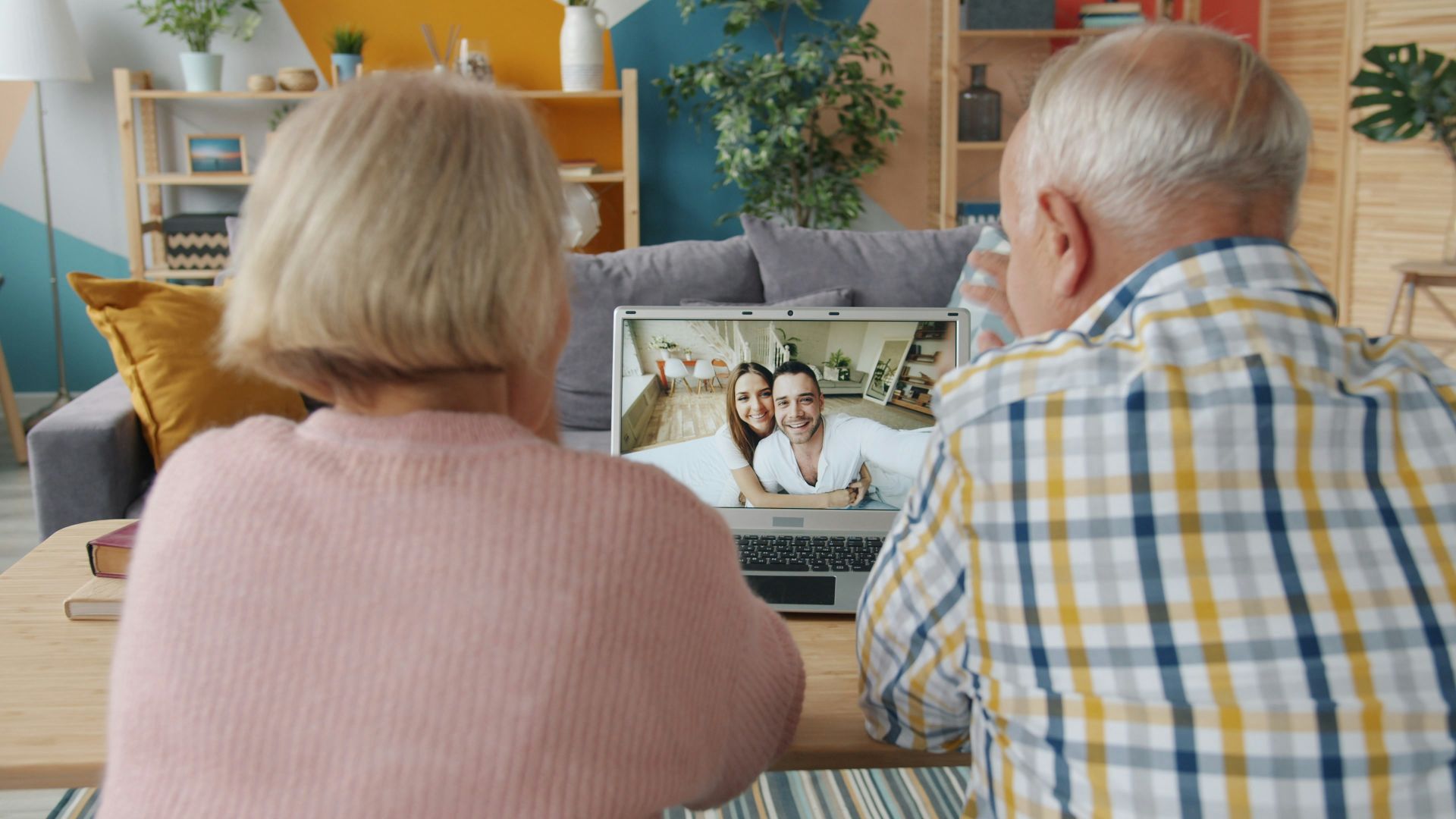 Elderly couple video calling with younger couple