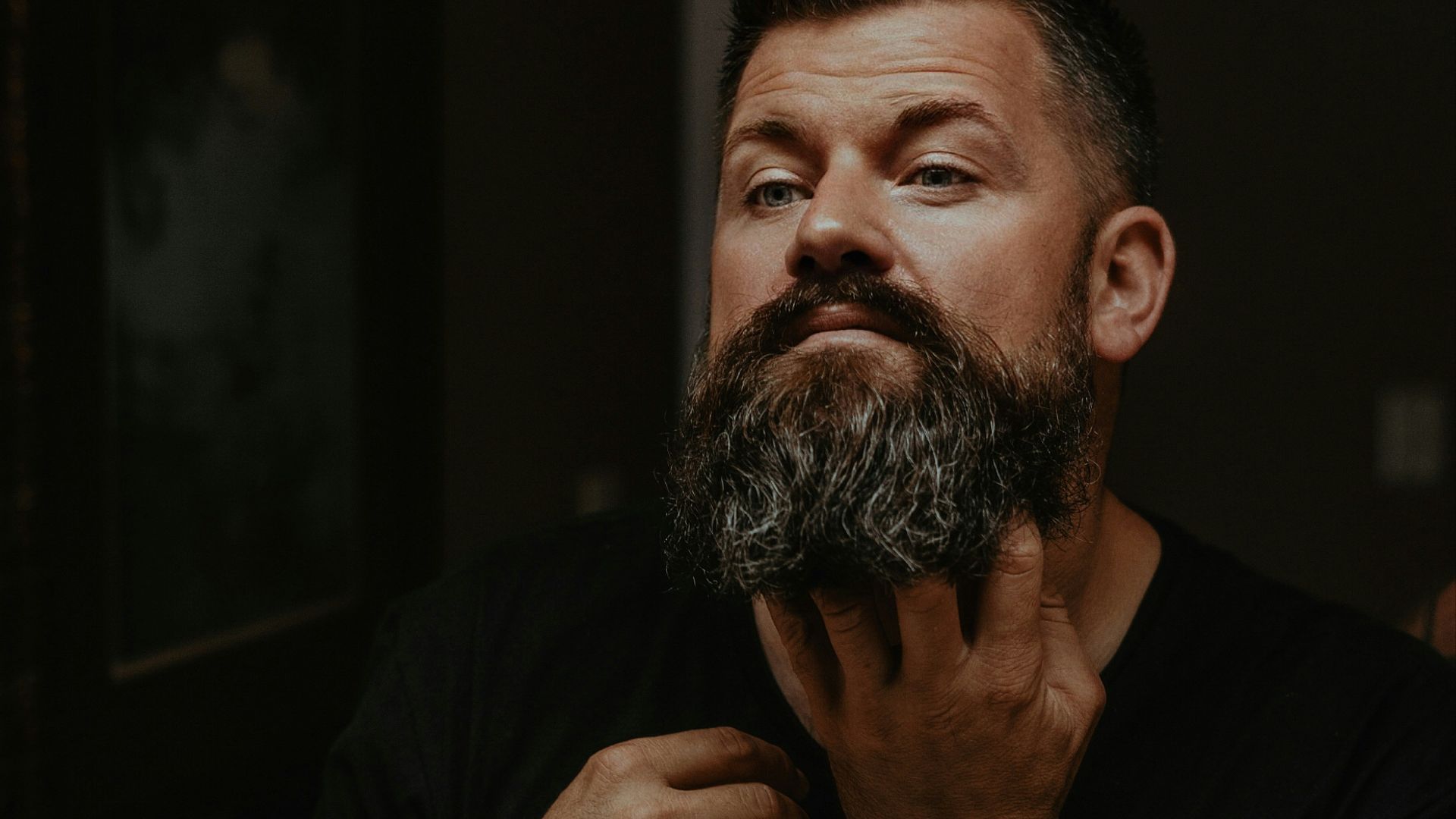 a man with a beard and a watch on his wrist