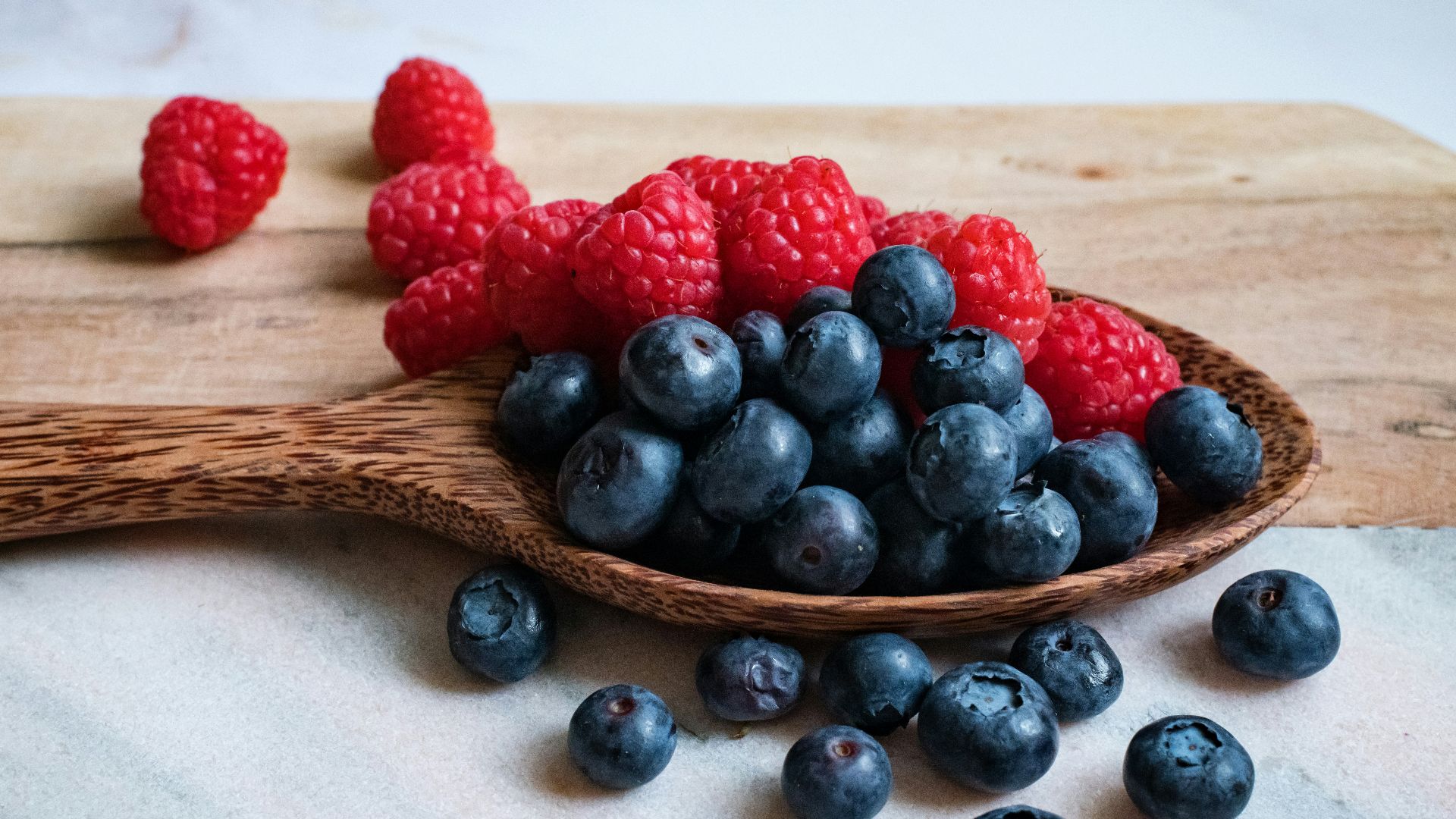 black berries on brown wooden spoon