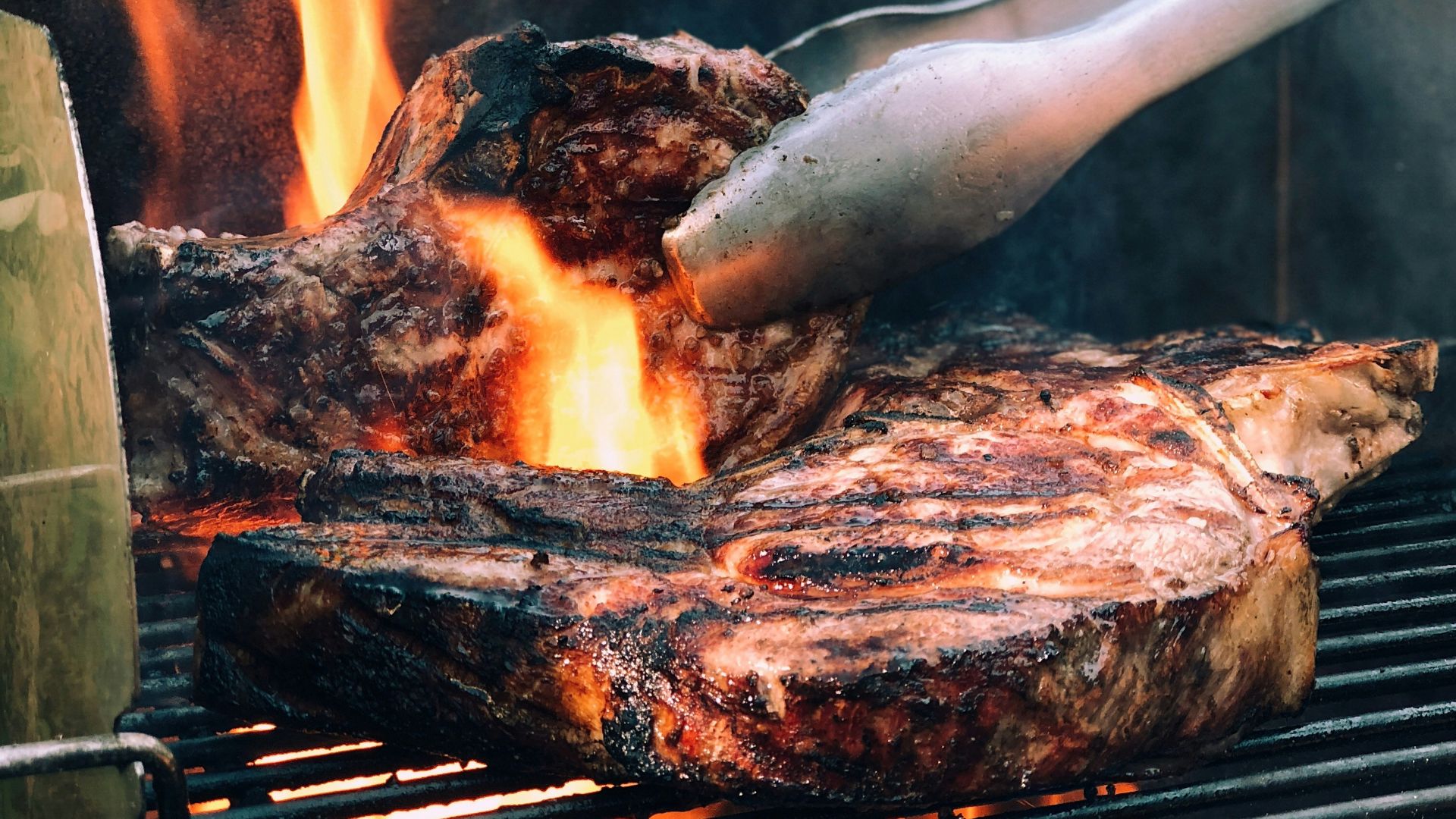 gray metal tong and grilled meat with fire