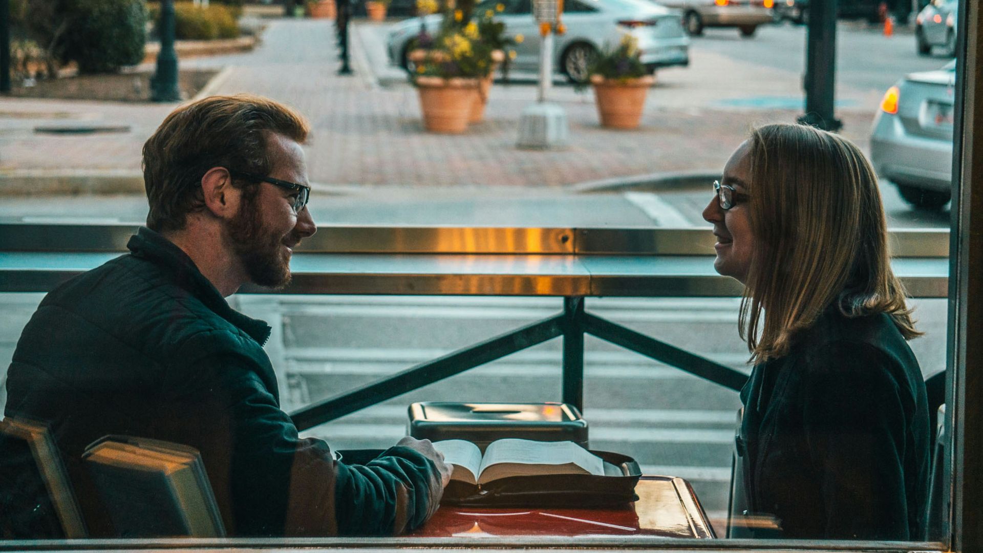 man and woman sitting while talking during daytime