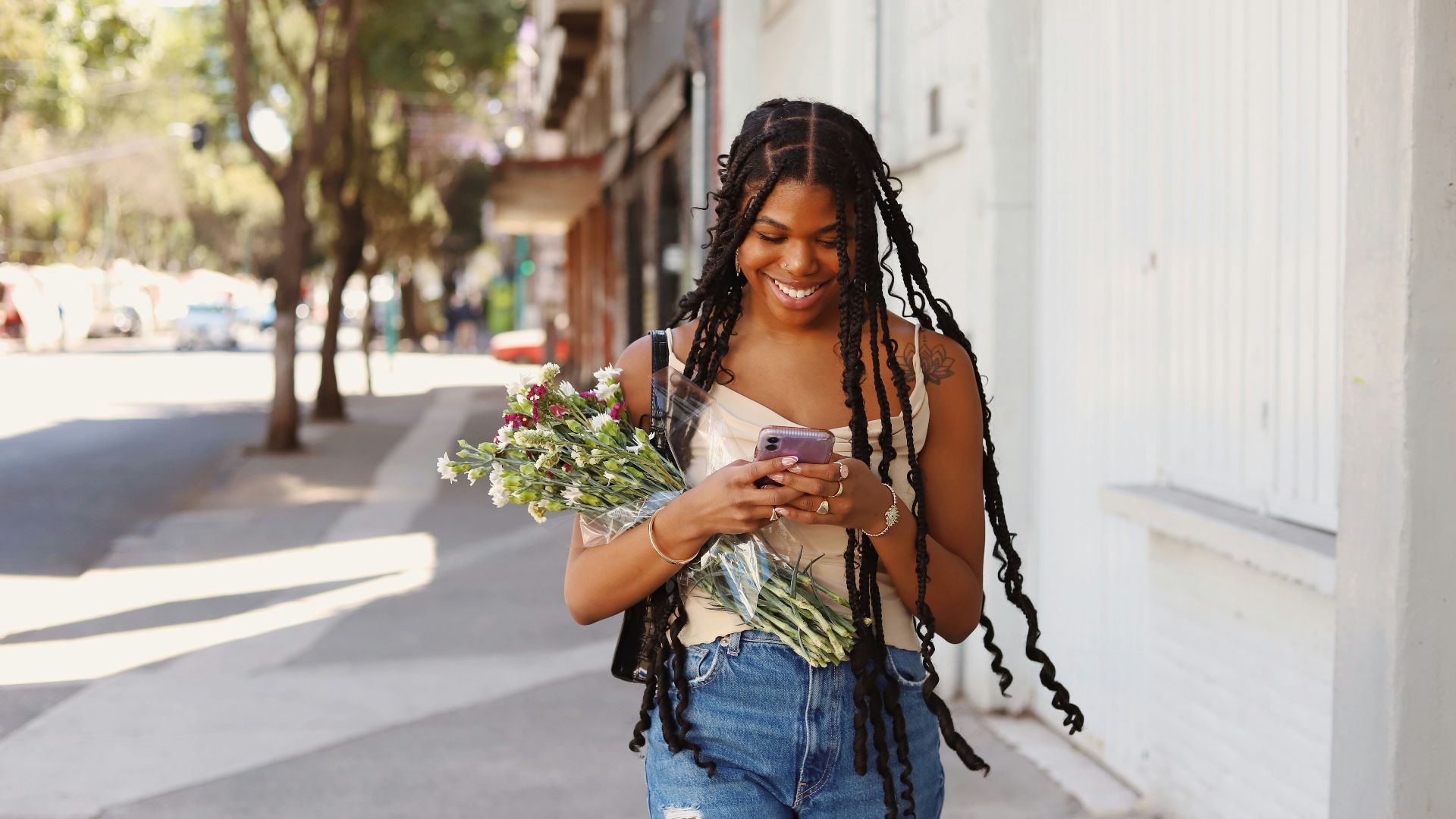 a woman walking down the street looking at her cell phone