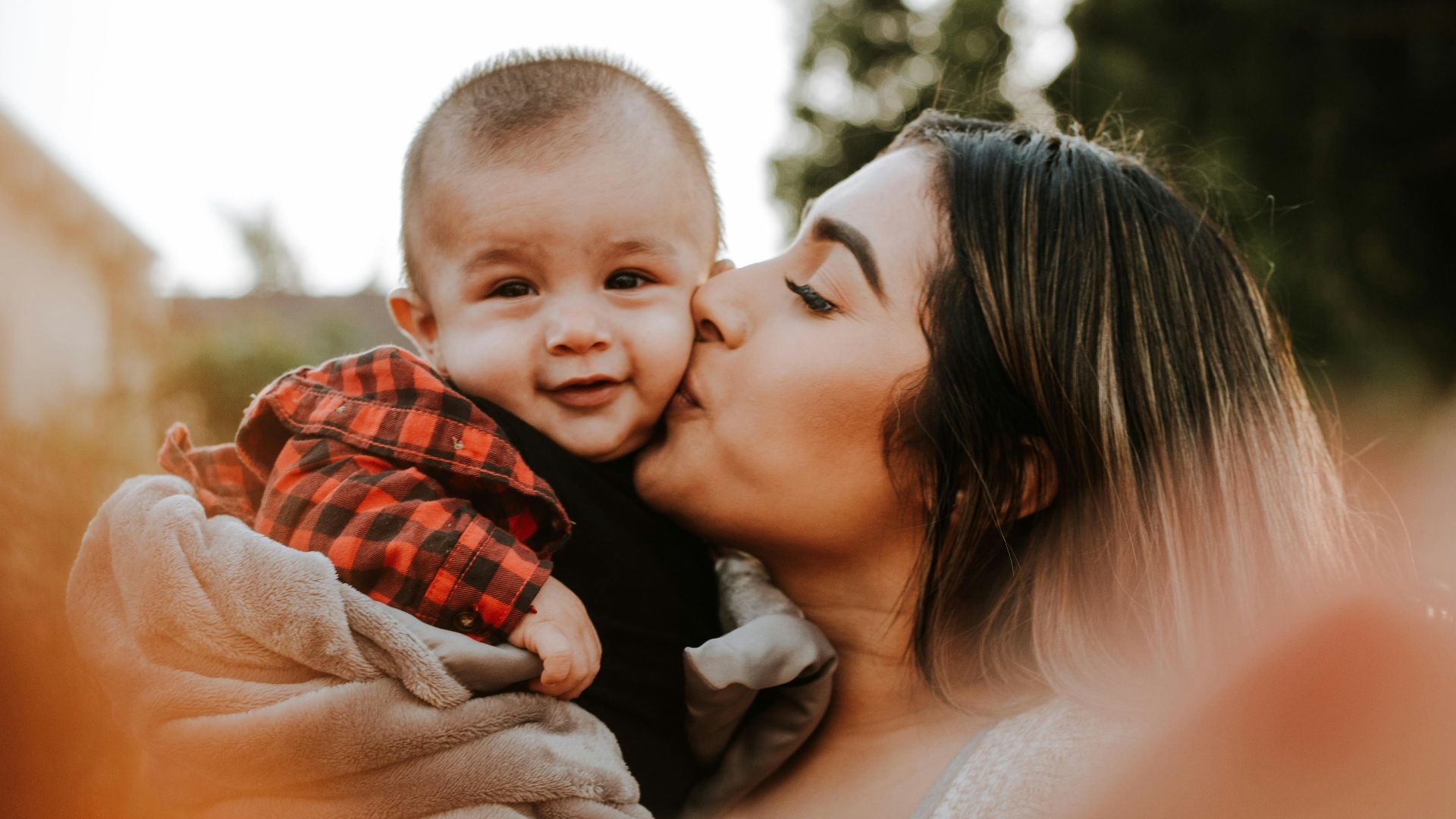 woman kiss a baby while taking picture