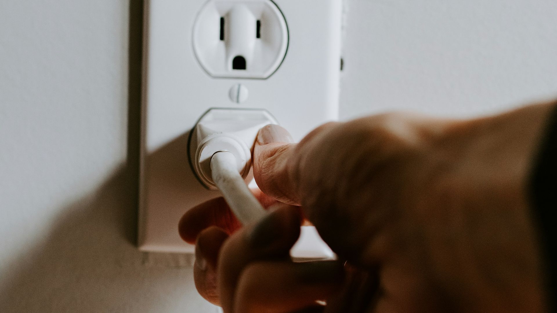 person holding white electric plug