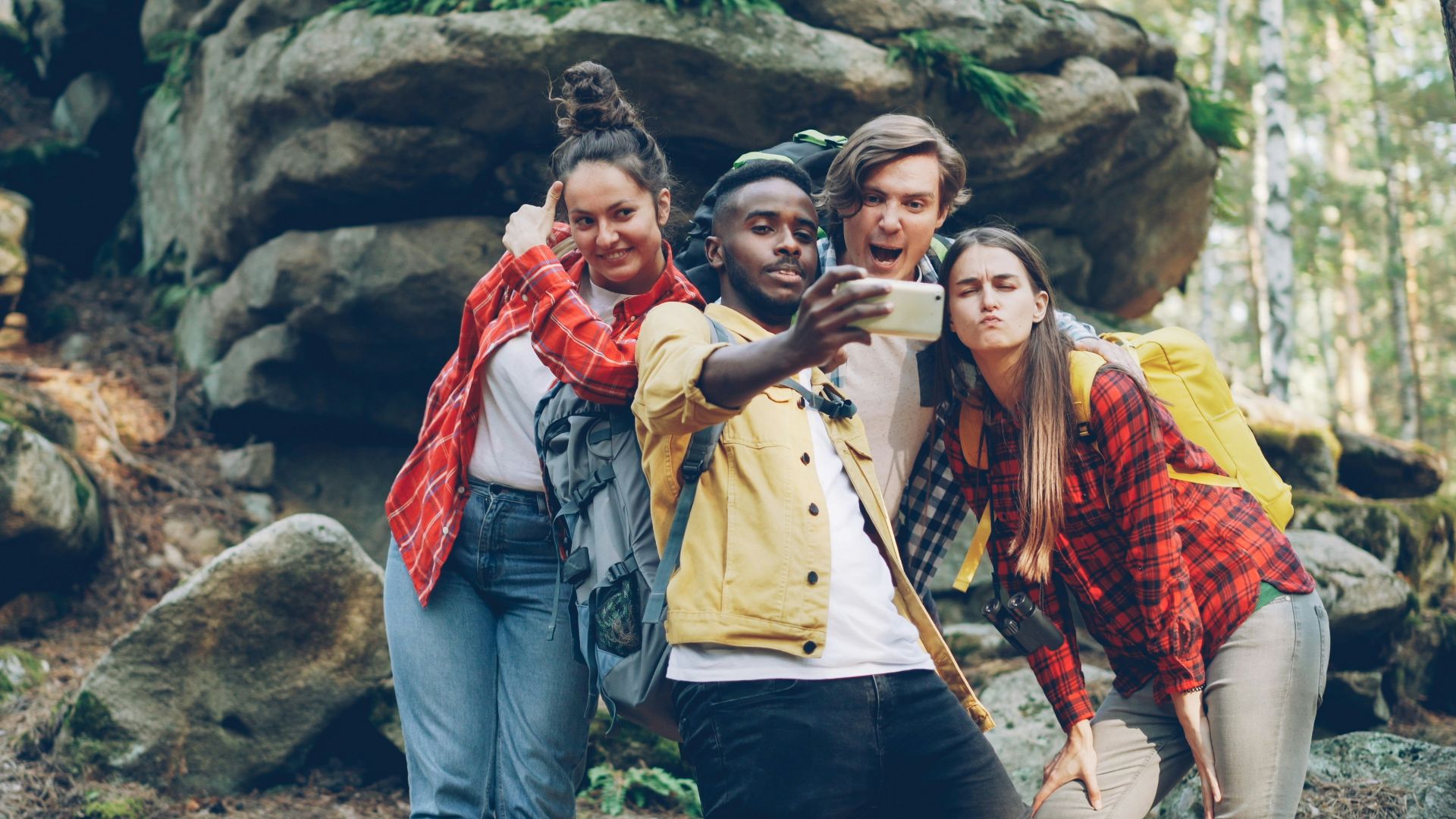 Four friends taking a selfie in a rocky forest
