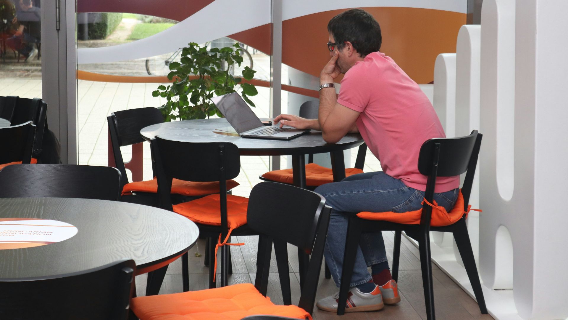 A man sitting at a table using a laptop computer