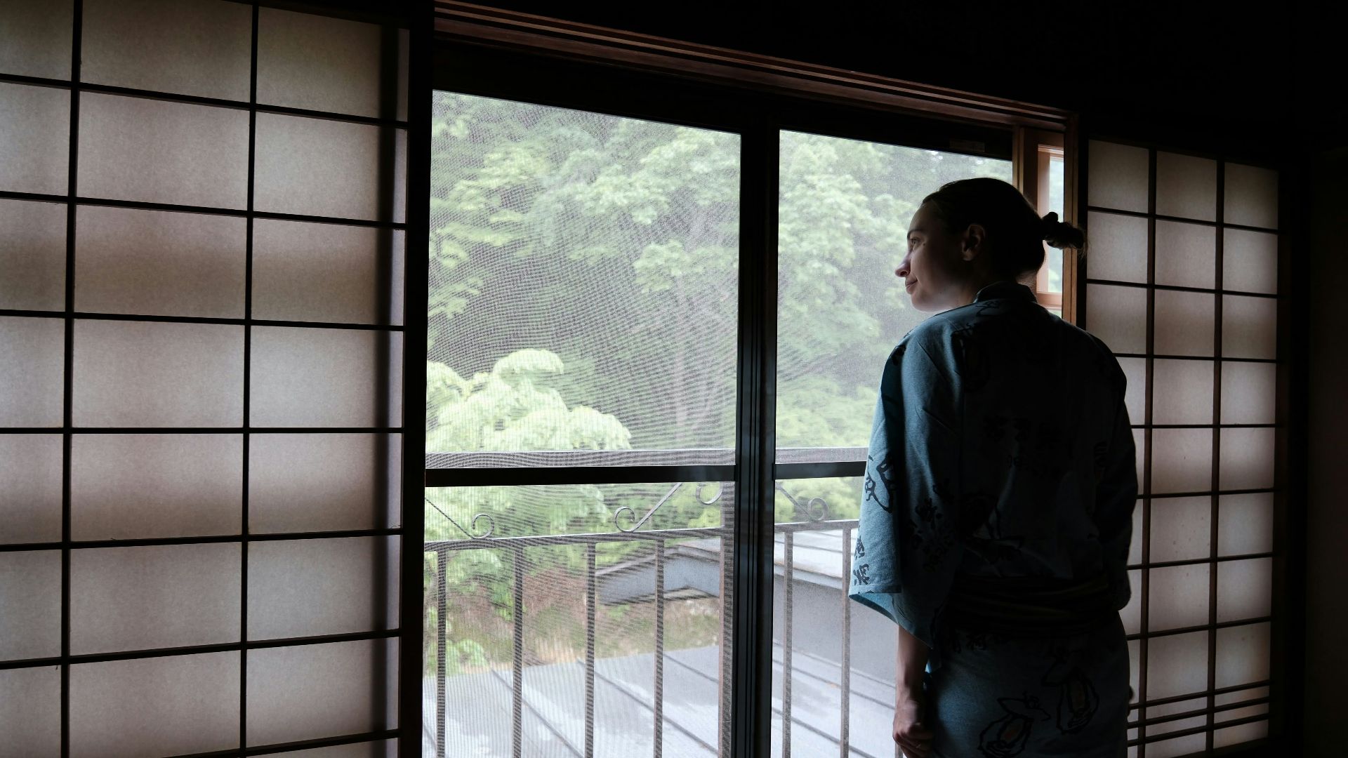 a woman in a kimono looking out a window
