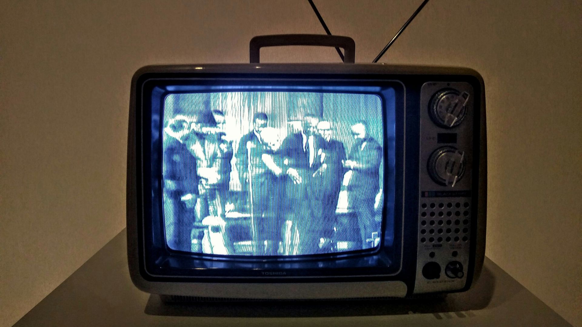 black crt tv turned on on white table