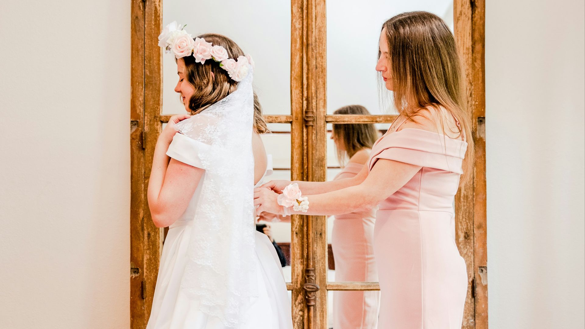 a woman in a wedding dress standing in front of a mirror