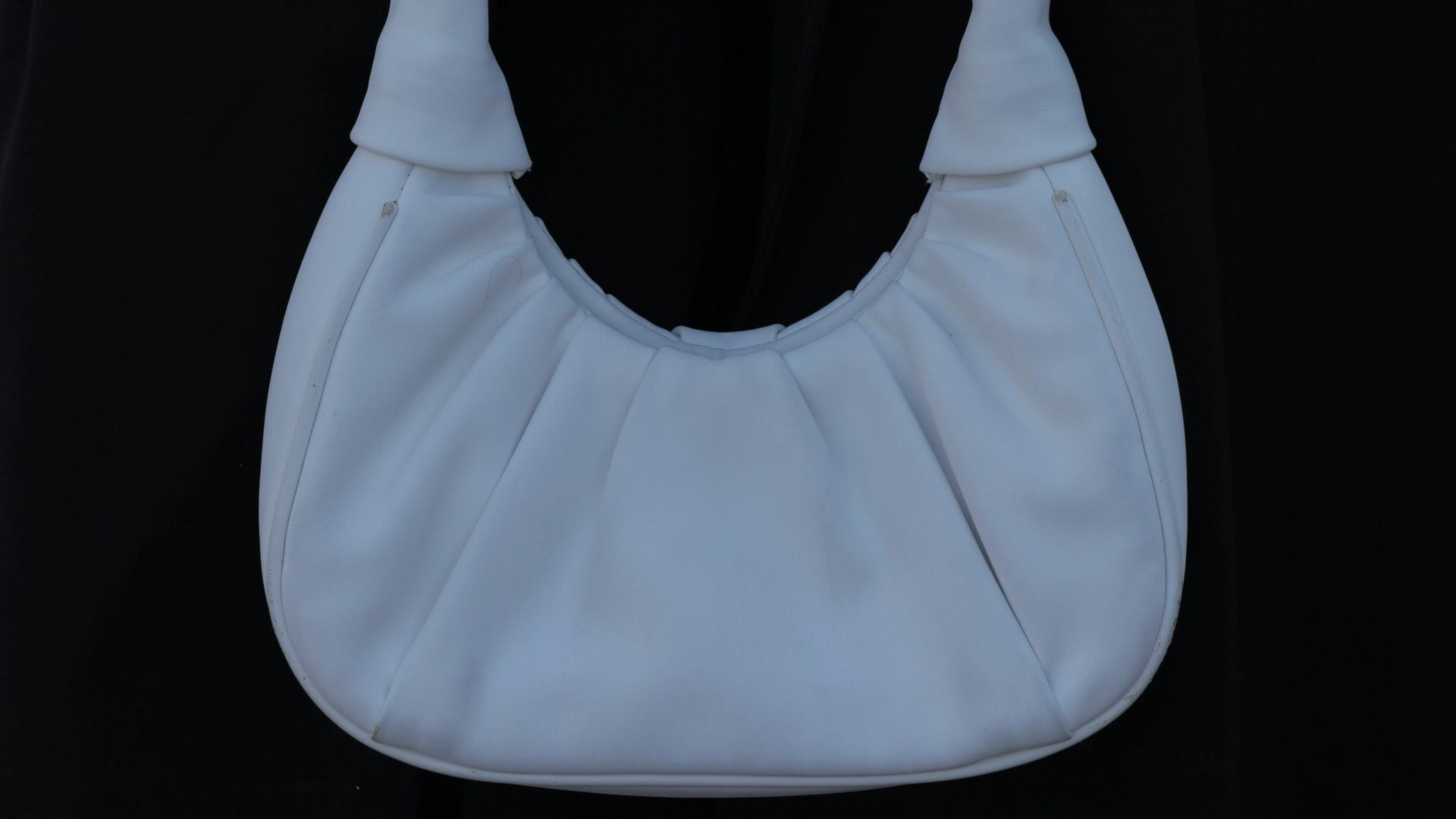 a person holding a white purse