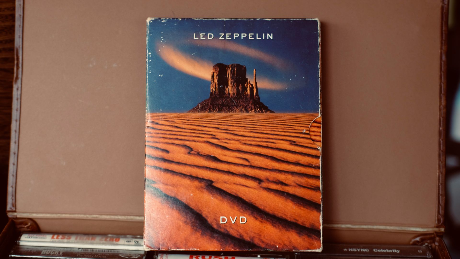 Led zeppelin dvd inside a brown case.