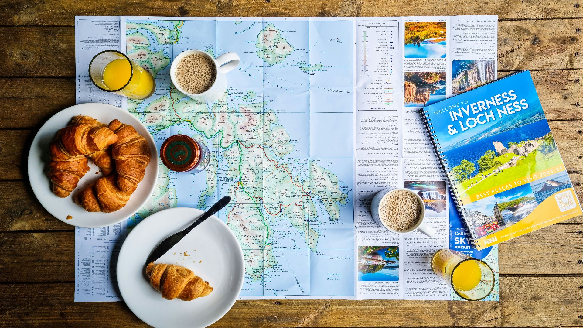a map, a plate of croissants, a glass of orange juice