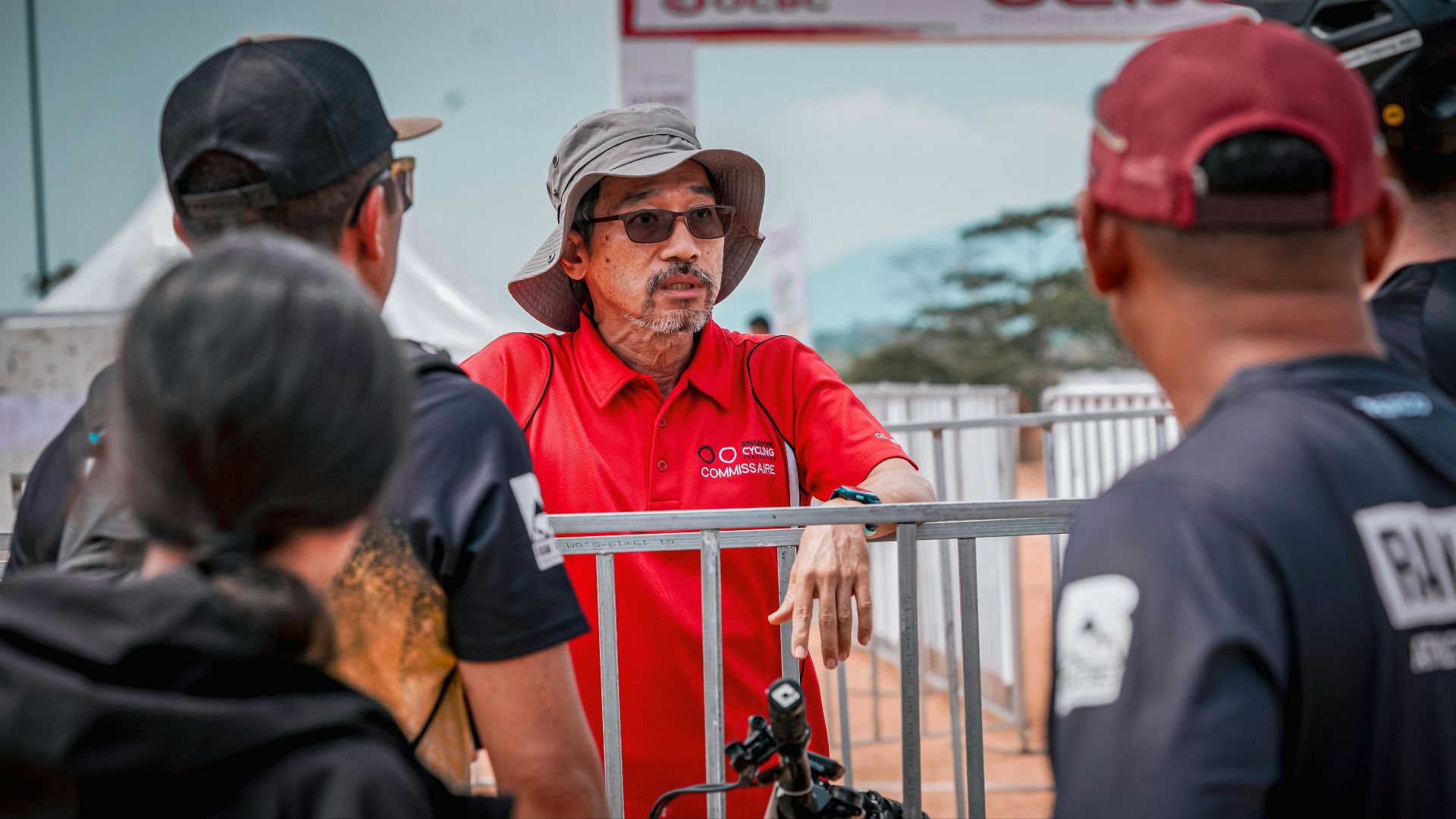 A man in red shirt looks at other people.