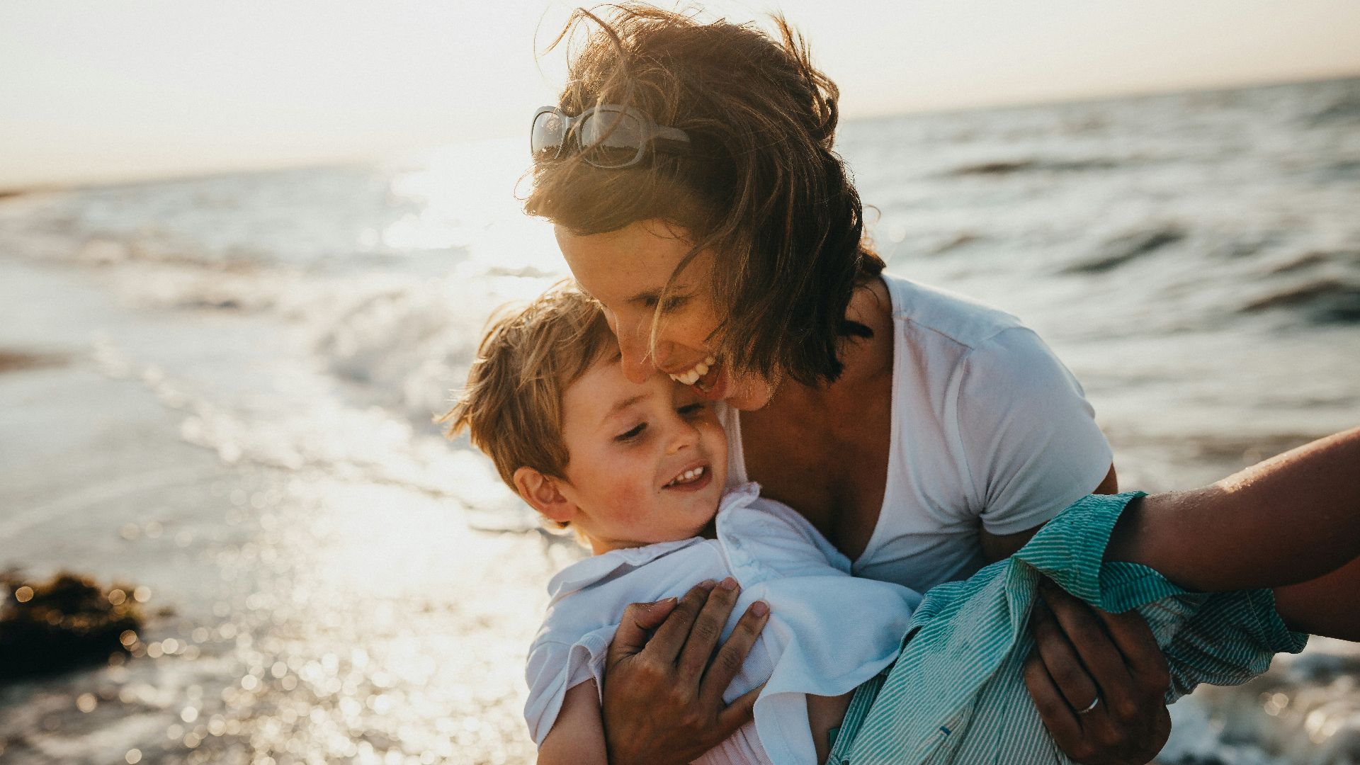 photo of mother and child beside body of water