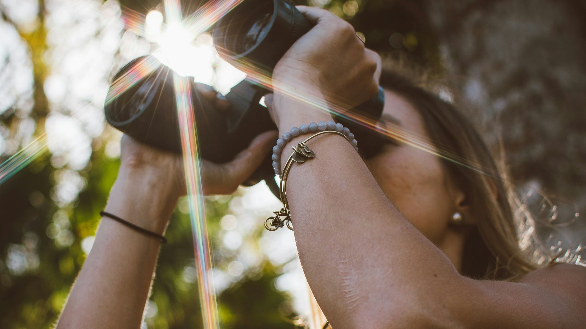 woman using binoculars in forest